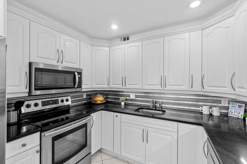 Beautifully renovated 4th floor 2 bedroom, 2 full bath unit in highly desirable Yarmouth in Century Village. This condo has ALL the bells and whistles including an updated kitchen with white shaker cabinets, granite countertops, stainless steel appliances and recessed lighting, 2 updated bathrooms, a new electrical panel, crown molding, smooth ceilings, new a/c and hot water heater, high end fixtures, custom window treatments, impact windows on the patio, and the list goes on, Beautiful ceramic tile throughout the living area and carpet in the bedrooms. Just steps from the clubhouse and places of worship. Century Village is a premier 55+ community with resort style amenities which include multiple pools, a fitness center, card rooms, a huge theater, pickleball, and the list goes on.