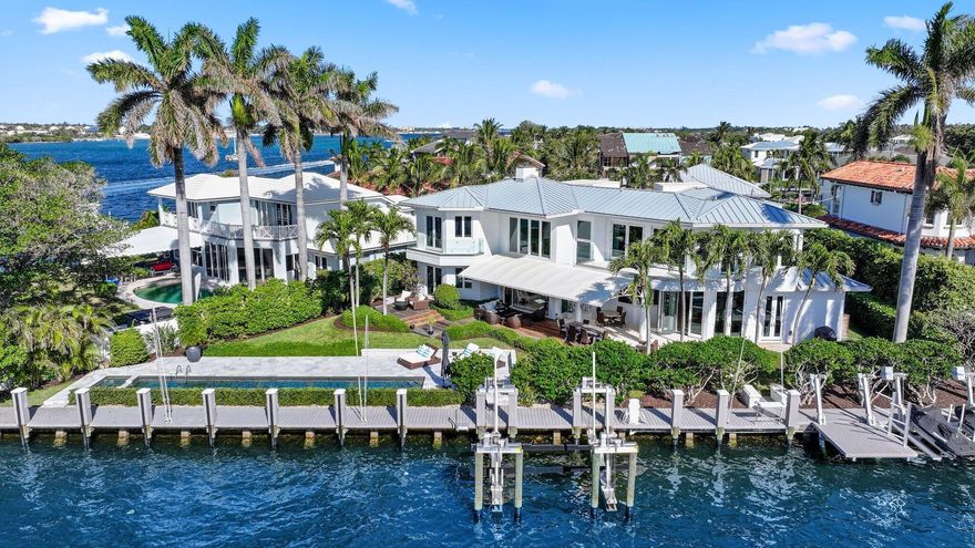 This outstanding 5 Bedroom 3.5 Bath contemporary waterfront sanctuary perfectly blends modern luxury with the ultimate Florida lifestyle. Boasting 166 feet of protected deep water dockage with wide Intracoastal views, it is just seconds to the Boynton Beach Inlet.Step inside through a custom mahogany door and be immediately captivated by breathtaking Intracoastal views. The spacious living room features soaring volume ceilings and a stunning gas/wood-burning fireplace, creating a warm and inviting atmosphere. Designed with impeccable attention to detail, this home seamlessly blends elegance and functionality.