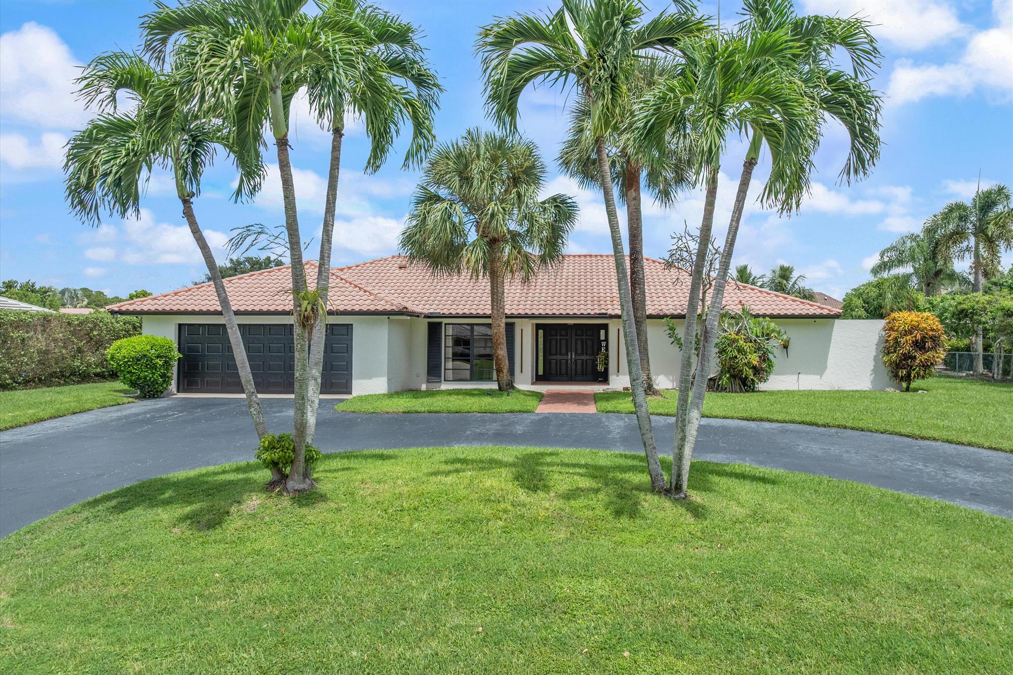 Welcome to the City of Atlantis! Situated on a spacious .32-acre lot backing onto the canal, this home offers both space and potential. The sellers began reimagining the residence--removing walls to open the main living area, installing new flooring throughout, updating the kitchen, and renovating several bathrooms--leaving a head start for a buyer ready to complete the vision. The 3-way split floor plan ensures privacy, while new impact sliders line the entire back of the home, seamlessly connecting indoors to the outdoors. A large covered screened enclosure with pool, generous green space, and a summer kitchen (with water hook-up) create the perfect retreat.The 4-bedroom, 3-bath layout is both functional and versatile. The primary suite is a true retreat with two walk-in closets,