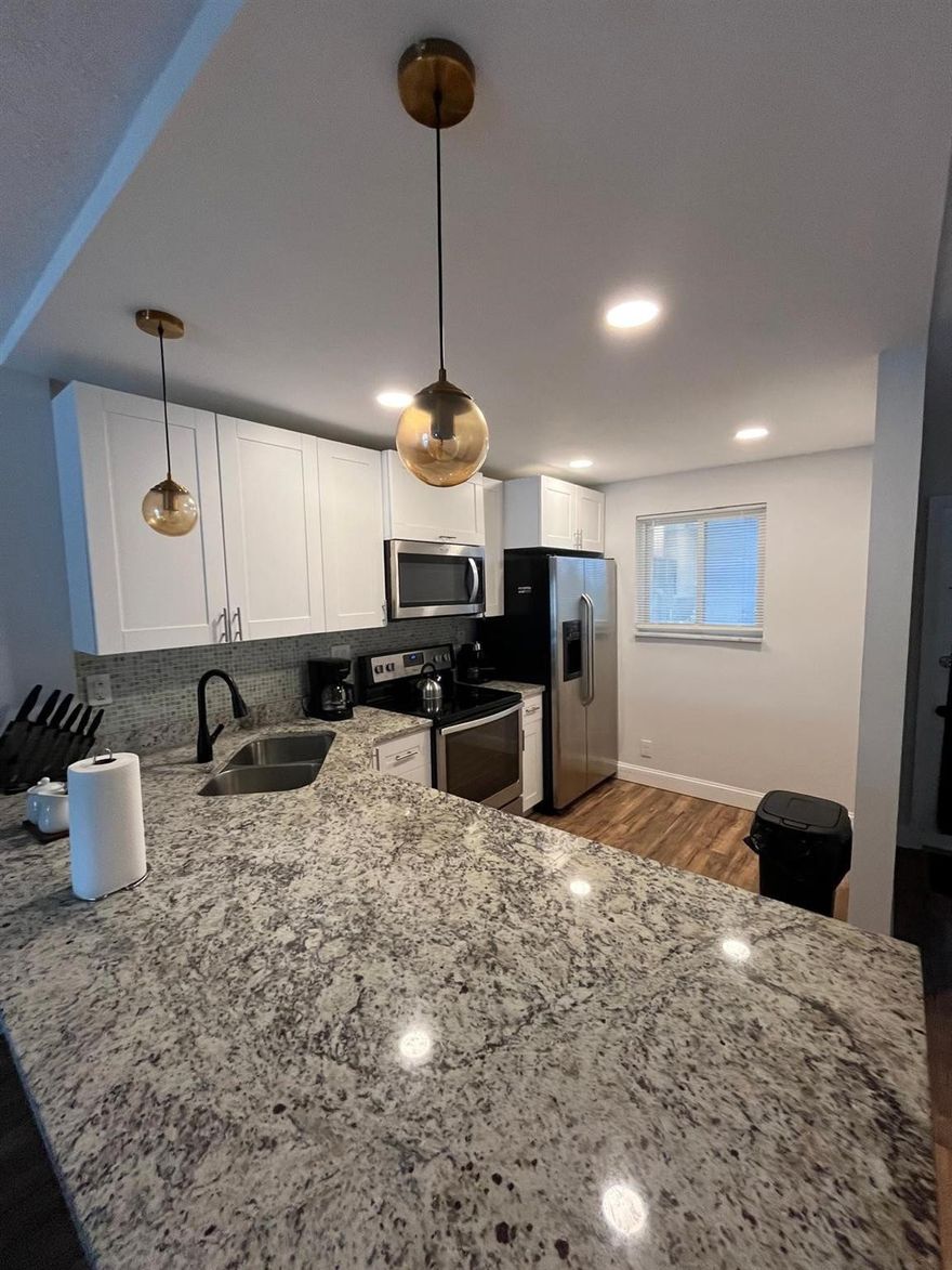 Centrally located corner unit in desired OMEGA Condo Complex. This large remodeled one bedroom and two full bathroom unit, has its own washer and dryer.  Remodeled kitchen features marble countertops and new stainless-steel appliances.  Large porch facing the lush green space. No assessments and building has reserves. Pets allowed, rental allowed: once a year, no waiting period. Community has auditorium, tennis, paddle board, two pools, and exercise room. 40-year inspection COMPLETE, 2023 roof, and elevator. 45 of 99 year land lease. Total land lease and rec. maintenance monthly is $107.93 + maintenance $462.26 = $570.19