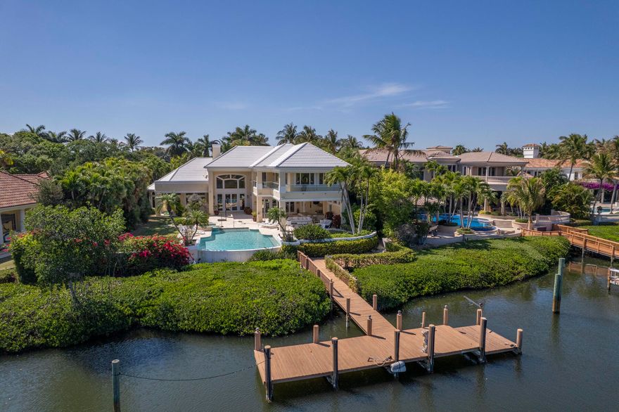 Rare opportunity to live on the most sought-after street of Spyglass Court in Admirals Cove, Offering breathtaking views across a protected barrier island with no homes across, creating unmatched privacy and coastal beauty. Situated on an expansive 28,749± sq ft lot, this 9,290 sq ft residence features dramatic open spaces, soaring ceilings, and stunning water views from nearly every room. The luxurious primary suite includes a newly renovated bath, while a private guest suite with kitchenette is ideal for visitors. Enjoy a resort-style backyard with expansive loggia and summer kitchen. Boater's dream with private dock, NO fixed bridges, and quick ocean access. Newer roof. Experience the ultimate Admirals Cove lifestyle — where you never have to leave unless you want to. Required golf membership purchase conveys all the first class amenities of Admirals Cove including two spectacular clubhouses, 45 holes of golf, 5 restaurants, 58 slip marina with floating docks, Yacht Club, 9 har tru tennis courts, 12 pickleball courts, state of the art fitness and wellness center with Technogym machines, 21,000 sq ft spa & salon, 30 room Waterside Private Boutique Hotel for members and their guests, brand new Golf Learning Center, Covesters kids club, dog park and Platinum service. Close to Palm Beach international airport .