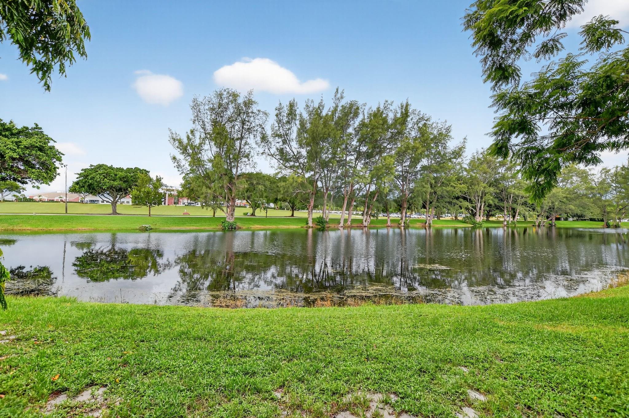Paradise awaits in this UPDATED 1ST FLR, 1 bdrm, 1.5 bath condo located just steps to the magnificent CLUBHOUSE! Enjoy gorgeous sunsets from your back patio w/a beautiful view of the LAKE. Convenient pkg. rt outside your front door. Many wonderful features incl tile flrs thru-out, lovely galley kit w/granite cntrs, NEW A/C, remodeled bathrms w/tub/shower in primary & roll up shutters in patio. Unit comes nicely furnished incl 2 sleeper sofas in liv rm! Fully equipped & ready to move right in! YOU WILL LOVE TO CALL THIS HOME! Gated comm w/24 hr sec, free busses, pools, tennis, pickleball, cafe, putting green, shuffleboard, STATE OF THE ART CLUBHOUSE w/fitness cntr, indr & outdr pools, classes & clubs of every type, free movies, theater. Close to shopping, beach & dining! Assoc. Claims 55+
