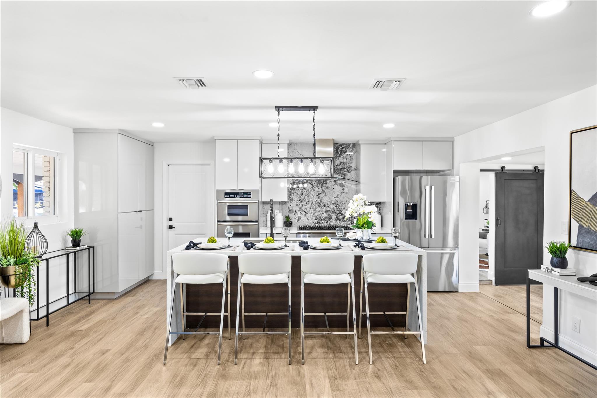 Fully renovated waterfront home with stunning canal views! This open-concept beauty features a new roof, new AC, new plumbing, and hurricane-impact windows and doors. The designer kitchen boasts waterfall quartz countertops, custom cabinetry, and premium finishes. Enjoy elegant flooring, high-end design throughout, and tranquil waterfront living. Every detail has been thoughtfully updated for modern comfort and style—move-in ready and built to impress!