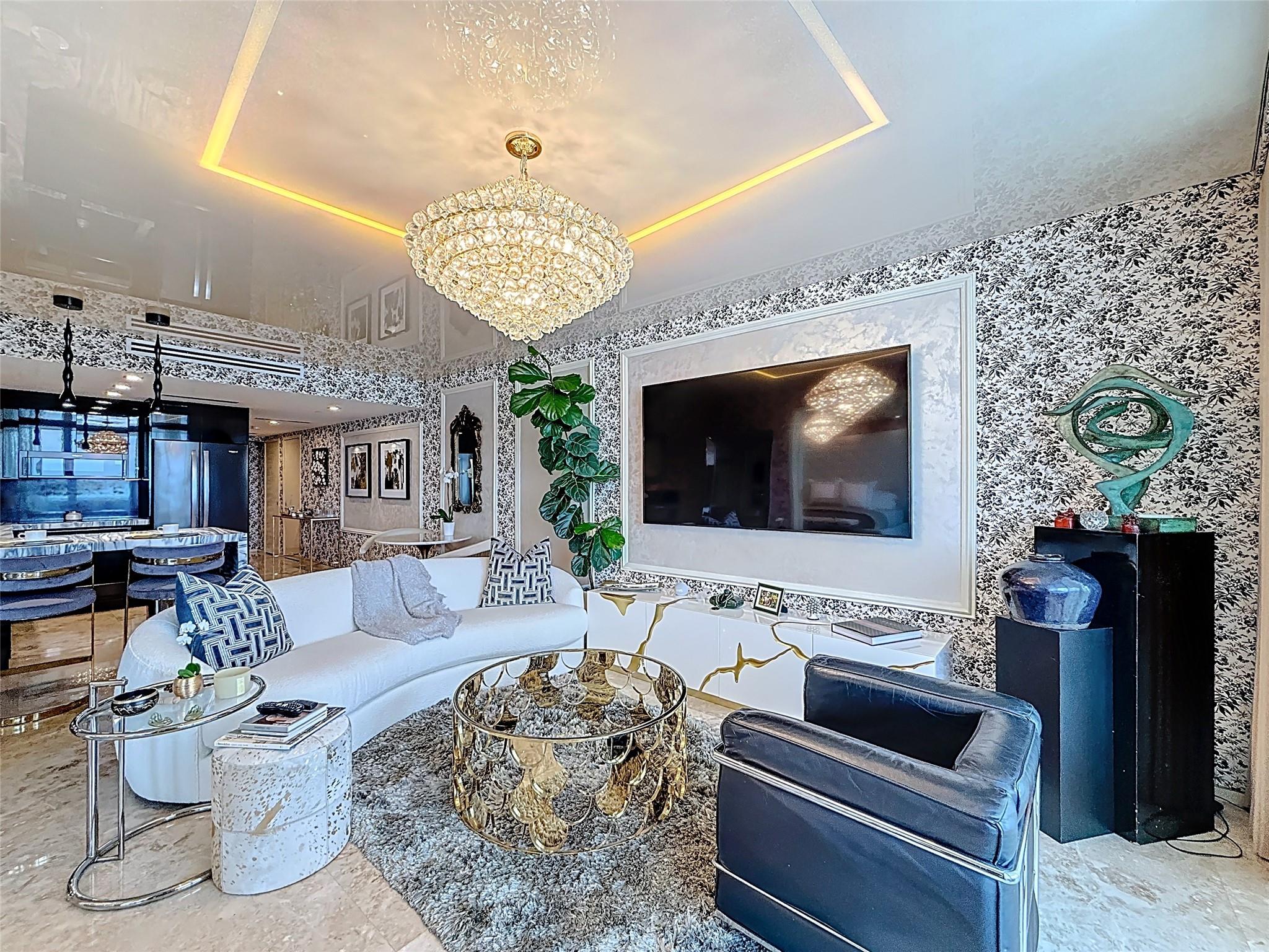 House of "Gucci by the Sea". Step into a world of elegance where every detail whispers luxury. This designer residence features iconic Gucci wallpaper and over $200K in bespoke upgrades, blending high-fashion aesthetics w/coastal sophistication. Most furnishings are included making this a move-in ready sanctuary unlike anything else on the market. Pictures cannot capture the essence of this extraordinary home. This is where fashion meets the ocean. Some of the upgrades included are illusion ceilings with integrated LED lights, motorized curtains & blackout shades, Lutron lighting throughout, Gourmet kitchen w/waterfall stone counters & Whitehaus sink. Den has custom wall unit with Murphy bed. Beach Club offers resort style amenities including 2 story 50K sq. ft fitness center and spa.