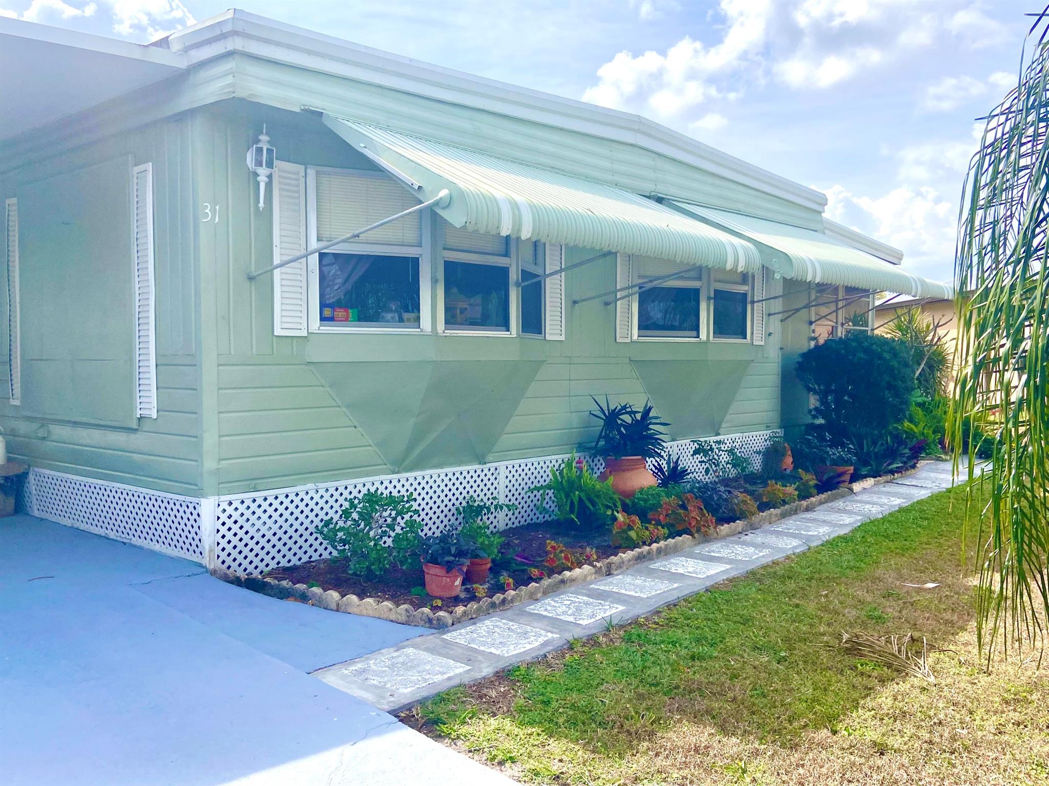 Yes! You've finally found that lake house you've been searching for at 31 Grande Vista Way! 3bedroom, 2 full baths and a grand island kitchen awaits! Fresh exterior paint, and 2 year old Central air, new roof 2020 and room for 4 car parking in driveway! Large shed at the end of driveway for all your toys! Offered fully furnished, and a large Florida room avails for great entertaining and loads of fun and relaxation at your fingertips! This active 55+ community allows for resort style living at it's best with 9 hole golf, tennis, pickle ball, games galore and 2 swimming pools and more! Land lease includes lawn care, trash , recycle and OWNER ONLY FREE GOLF! This is one of the most sought after lots in the community with fantastic sunrise views to enjoy all year! Don't delay Call NOW!
