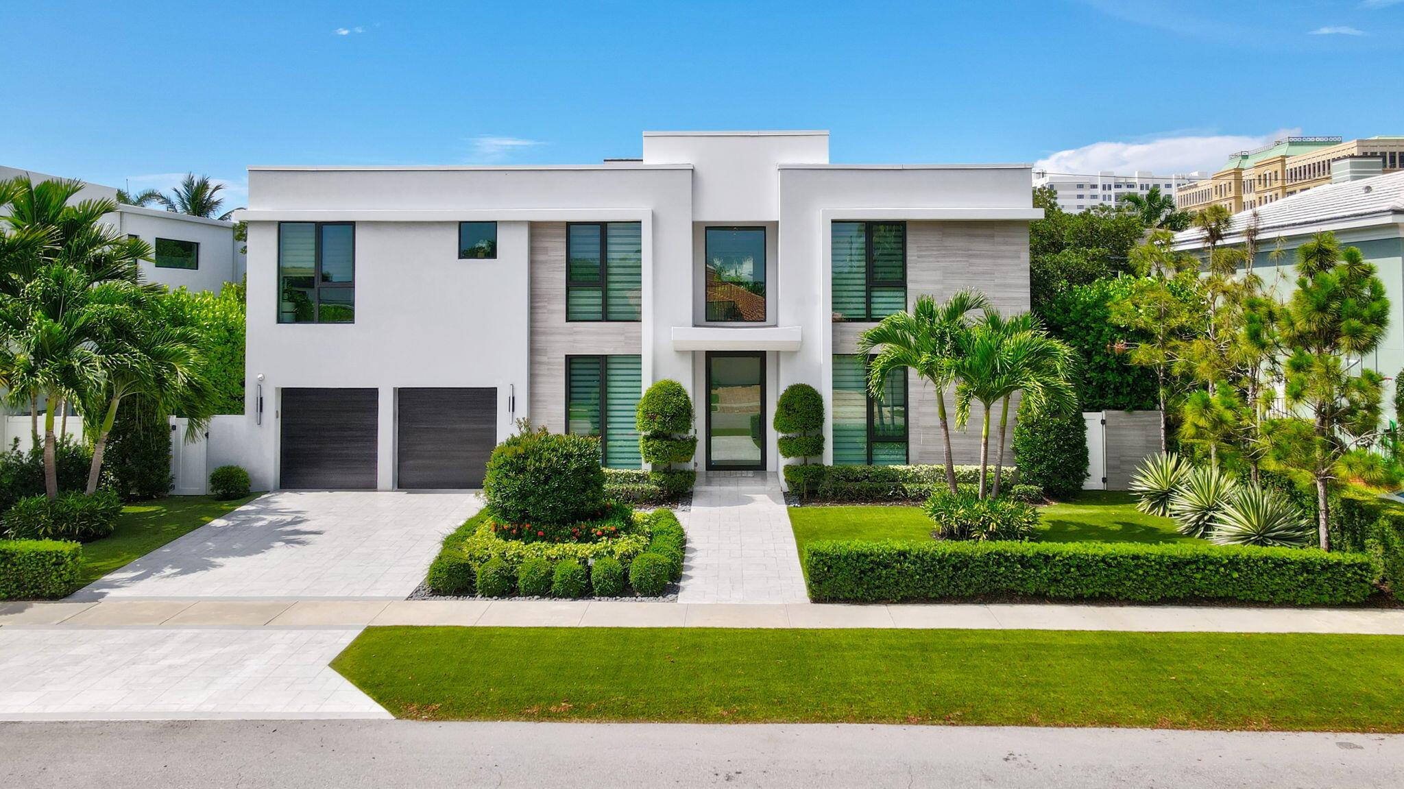 Situated in one of East Boca Raton's most coveted neighborhoods, this five-bedroom, five-and-a-half-bath contemporary estate lies just steps from Mizner Park and moments from the beach. Located in the heart of the Golden Triangle, this property offers unmatched walkability to Boca's top restaurants, shops, and cultural attractions--all while tucked into a quiet, tree-lined street. Inside, clean modern lines and walls of glass create a bright, airy feel throughout. A dramatic floating staircase beneath a glass skylight anchors the entry, setting the tone for bold, sophisticated living. The open-concept main floor features a sleek chef's kitchen with professional-grade appliances, a waterfall-edge bar, and spacious living and dining areas perfect for entertaining. Glass sliders open to a