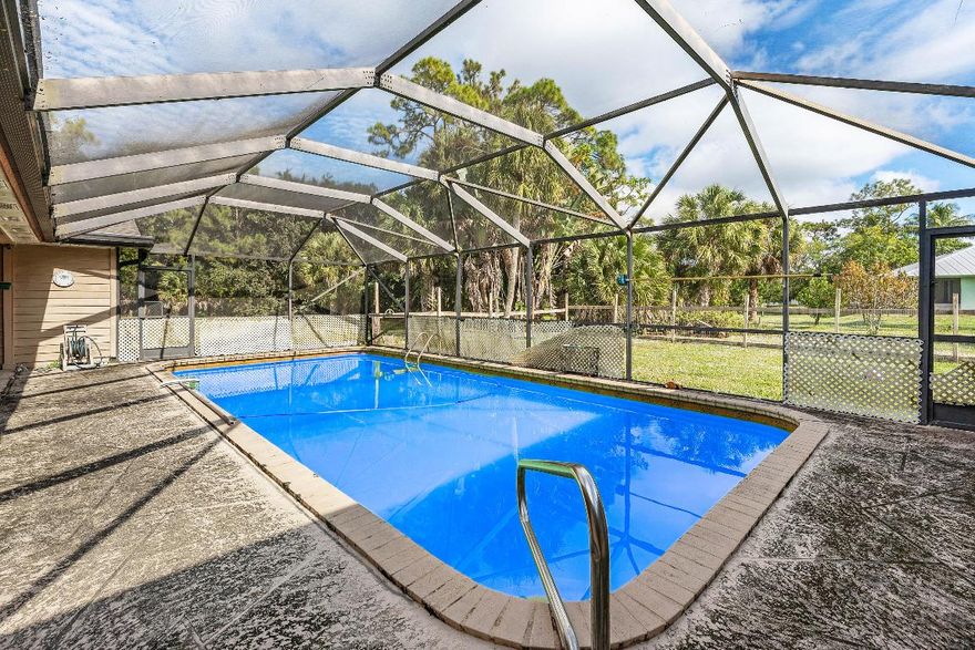Bring your vision and make this 5BR/2.5BA/2 CG pool home on 1.25 acres the dream retreat you've always wanted. Tucked back on a paved road, this sprawling property offers room for horses, toys, gardens, RVs or a workshop while still keeping you just minutes from shopping, PBIA airport, Wellington Mall and top hospitals. Inside, a flexible floor plan with generous bedrooms and gathering spaces is ready for your personal touch—add your favorite design details to transform ''needs a little TLC'' into ''better than new.'' Outside, the pool, patio and expansive yard are perfect for weekend gatherings, playtime, pets and quiet evenings under the stars. With all the space, privacy and convenience rarely found together, this is your chance to create your forever home all while building equity.