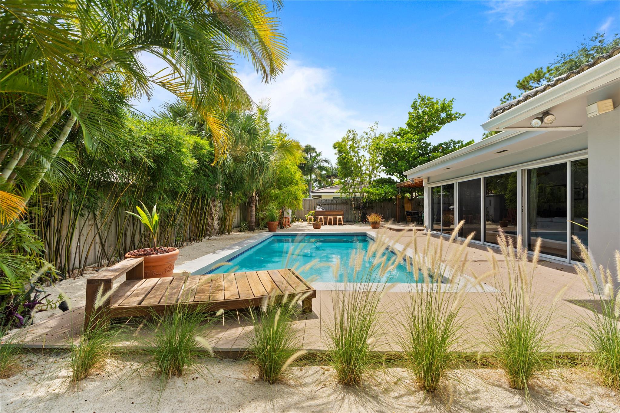 This beautifully maintained single-story home blends comfort, style, and Florida charm. Bright, open living spaces lead to a lush backyard with pool, covered patio, and multiple relaxing seating areas. The property features 2 bedrooms, 2.5 baths, and a versatile den that can be used as an home office, playroom or extra sleeping area. The Master suite boasts a large walk-in closet and en-suite bath; the guest bedroom has an adjacent full bath with tub/shower combination. The cabana bath provides convenient outdoor access for poolside guests. Large circular driveway, two-car garage, and excellent curb appeal. Minutes from Coral Ridge Country Club, beaches, dining, and shopping. Move-in ready—perfect as a primary home, vacation retreat, or investment property.