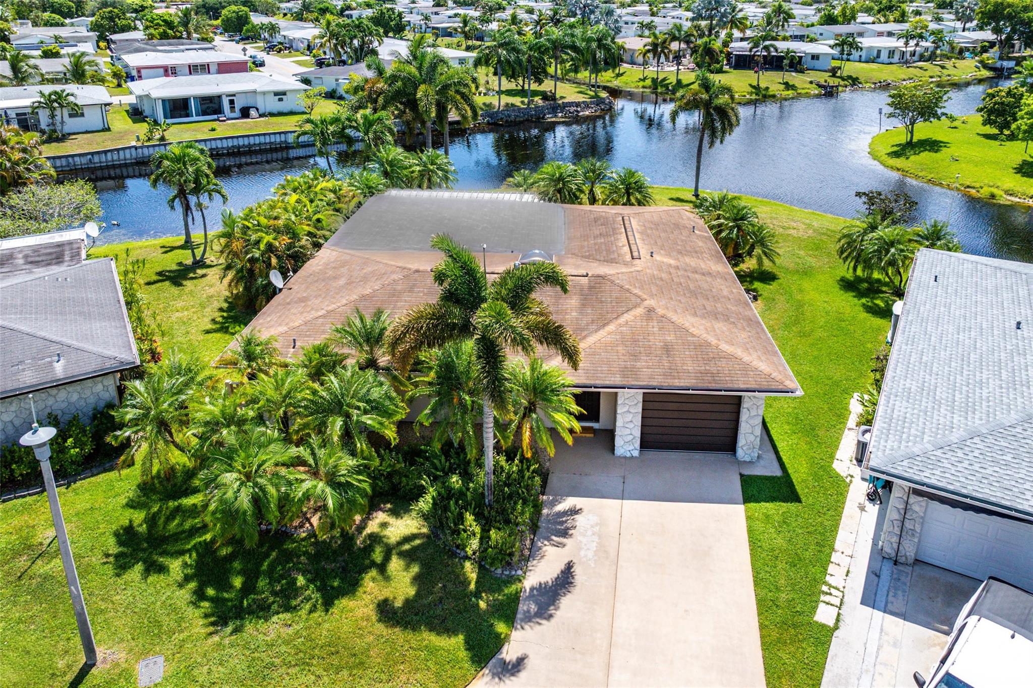 Fabulous 3 bedroom home perfectly sited on a beautiful point waterfront lot where multiple waterways converge, creating breathtaking panoramic views. Inside, the sun-drenched kitchen shines with granite counters, top-tier SS appliances, & opens to a jaw-dropping great room framed by walls of glass doors—bringing the serene water vistas right into your living space, Spacious primary suite with an ensuite bath & large closets. On the opposite side of the home, you’ll find two bedrooms, a full bath & a spacious laundry room. Step outside to an expansive backyard—an ideal retreat for relaxing, entertaining, or simply watching the boats pass by. Other offerings: Oversized driveway, Plantation Shutters, Accordion shutters, & the ability to enjoy boating from your backyard! 55 & over