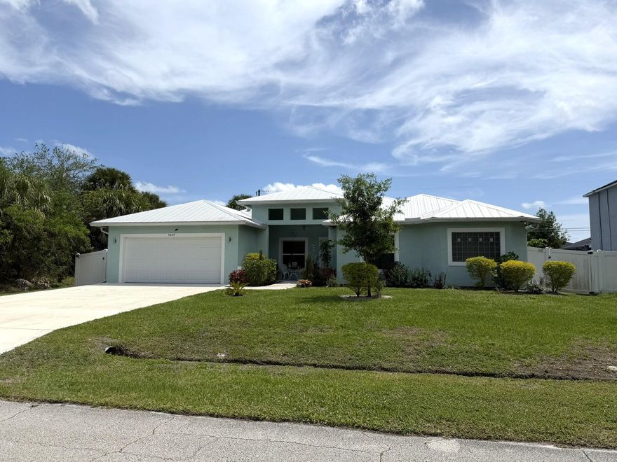 Spacious 5-bedroom, 3-bath home featuring a dedicated office and a separate family room. Beautiful quartz countertops flow seamlessly throughout the kitchen and bathrooms. The kitchen is highlighted by a modern glass backsplash and an abundance of tall cabinetry for ample storage. Porcelain tile flooring runs through the main living areas, with comfortable carpeting in the bedrooms. The master bathroom offers a luxurious freestanding soaking tub and a large walk-around shower.  This home also includes impact windows throughout, a durable metal roof with gutters, and a covered patio perfect for outdoor living. The oversized driveway provides plenty of parking, and the vinyl-fenced yard offers privacy and space to enjoy.  CLICK MORE Close to shopping, Medical and I-95 access.  Room sizes approximate to be confirmed by buyer.