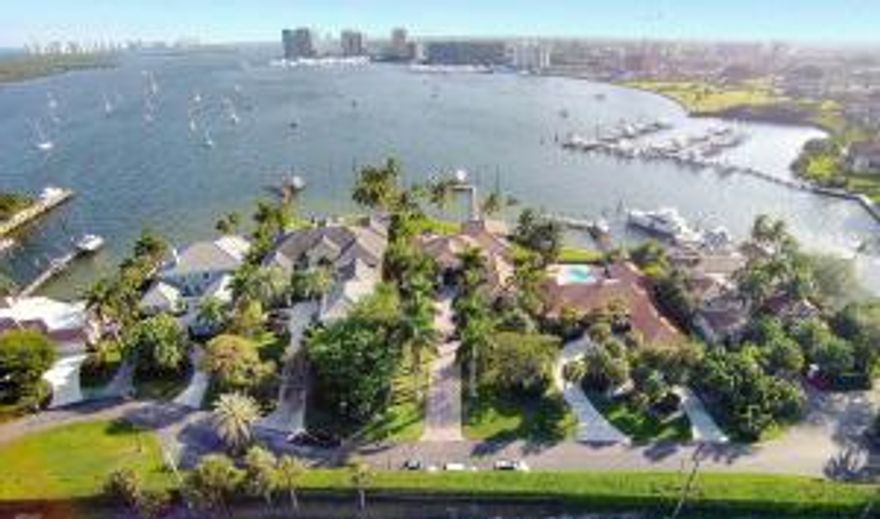 Rare opportunity to live the Northern Palm Beach Lifestyle with your yacht! Masterfully built home with one of a kind breathtaking view of direct Intracoastal in the exclusive community of Portage Landing South. The spectacular view and vast openness of the water along with the thoughtfully and tastefully appointed architectural details throughout (including first class fixtures and finishes) are what make this home so unique and desirable.   It is located in a gated private enclave on just over 1 acre of land and water with 133' of water frontage availing a beautiful southern exposure to the Intracoastal, no fixed bridges and direct ocean access.  Your experience begins driving up the long pavered drive framed by 8 mature Royal Palm trees.