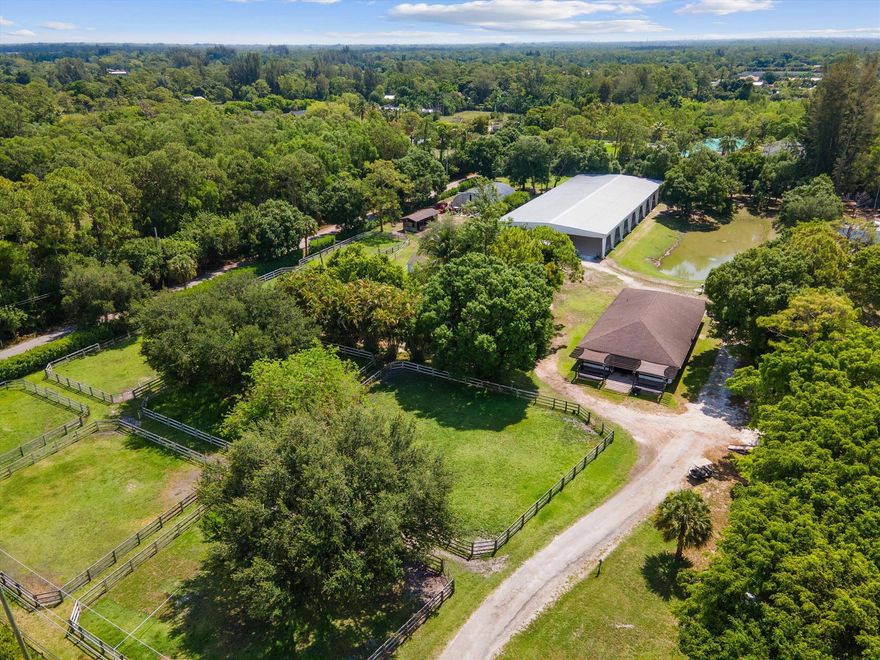 COVERED ARENA with concrete mirror wall, excellent footing and lights!!! This beautiful 5-acre property is perfectly set up for a dressage farm.  The center aisle cbs barn has 8 stalls, a spacious feed room, large tack room and laundry room / bathroom.  There are roll-up doors and shutters for hurricane safety. Each stall has fans and is hooked up to the fly spray system.  8 irrigated paddocks with shade trees and three-board fencing offer plenty of turn-out.  A Four-Horse Walker is conveniently located close to the barn. The 2 bed /2-bath home is built of solid concrete... including the roof! All windows and sliders are impact glass. This home is built rock solid for hurricane resistance and energy-efficiency. The large, covered patio looks out to the arena.