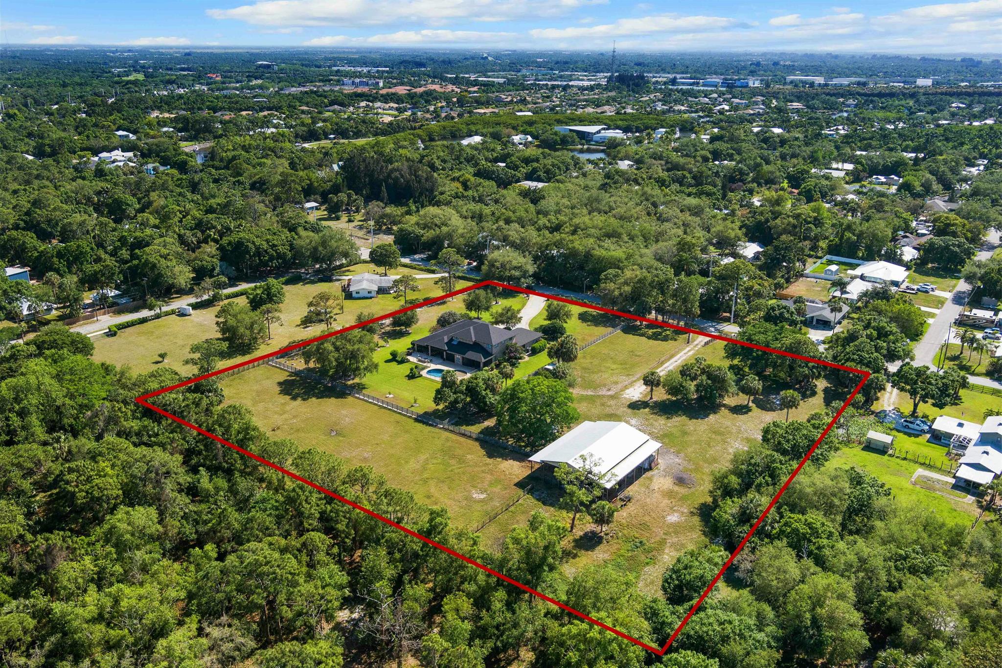 Land and location! A rare opportunity to own 4.75 acres right in Stuart! Tucked away in a peaceful, private setting, this one-of-a-kind estate offers the freedom and space of country living without giving up the convenience of town. The main home features spacious living areas, high ceilings, and great natural light with 4 beds, 3.5 baths and den/office space. Take advantage of Florida living year-round with multiple screened-in porches and a private saltwater pool. For equestrian lovers, the property features a versatile barn with 4+ stalls, and is large enough to accommodate an RV, boat, or workshop. Within 20 miles discover 4 state parks with over 65,000 acres of riding trails, the closest being less than 2 miles away. A truly unbeatable location!