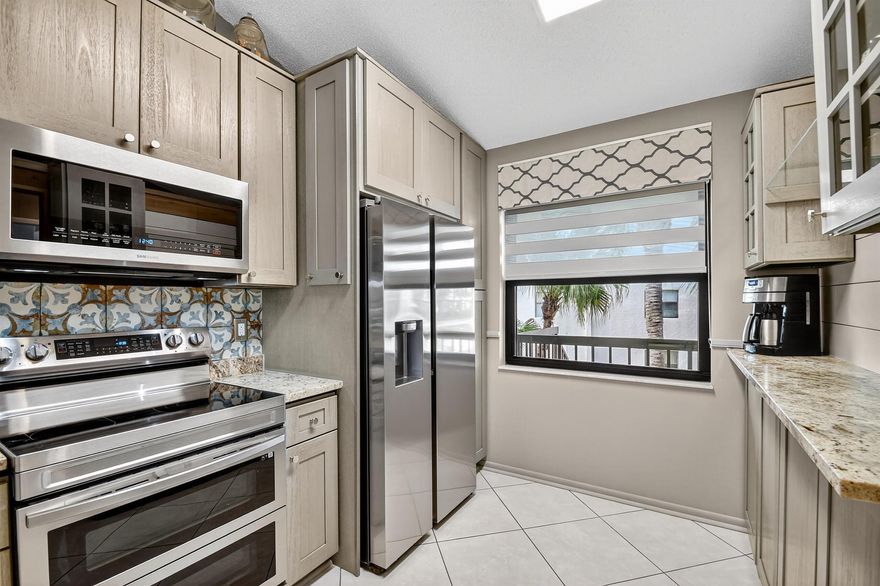 Impeccable, stunning aparment with views of water from all windows.  This end unit apartment with vaulted ceilings has been beautifully updated starting with high rated impact windows.  The a/c is a larger high efficiency unit, 2 yrs old. The water heater and washer and dryer are 4 years new. Bathrooms have been updated with frameless shower within 1 year.  Kitchen with extensive cabinets including by bar stools.  Built in firepalce with designer wood accents on wall - doors are upgraded with designer inserts.  The patio area has a/c and is part of the home.  The views are water and park areas.  This is a 2 story building and does not have state required engineering requirements. Roof is 6 1/2 years new.  This home is perfect.  Close to Turnpike, shopping movie theatre.