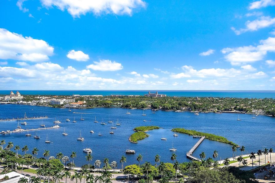 Breathtaking views high above downtown West Palm Beach. This 20th floor 3BR+ penthouse captures sweeping views of the Intracoastal, Palm Beach & the Atlantic Ocean. Thoughtfully designed for comfortable & sophisticated daily living & entertaining over expansive water views. Enjoy a graciously scaled open living room w/ a custom bar, 11' floor-to-ceiling glass & an open chef's kitchen. PH includes 2 premium parking spaces w/EV charging & climate-controlled storage w/electric & wine coolers. Building amenities include a rooftop pool deck w/ grills, dog park, & TVs, 24 hr security, plus a 5th floor gym, club room, theatre, & spa w/ steam & dry saunas. No upcoming assessments. Seller open to selling w/ furniture. Moments away from downtown WPB & PB, PBI Airport, & world-class dining & retail.