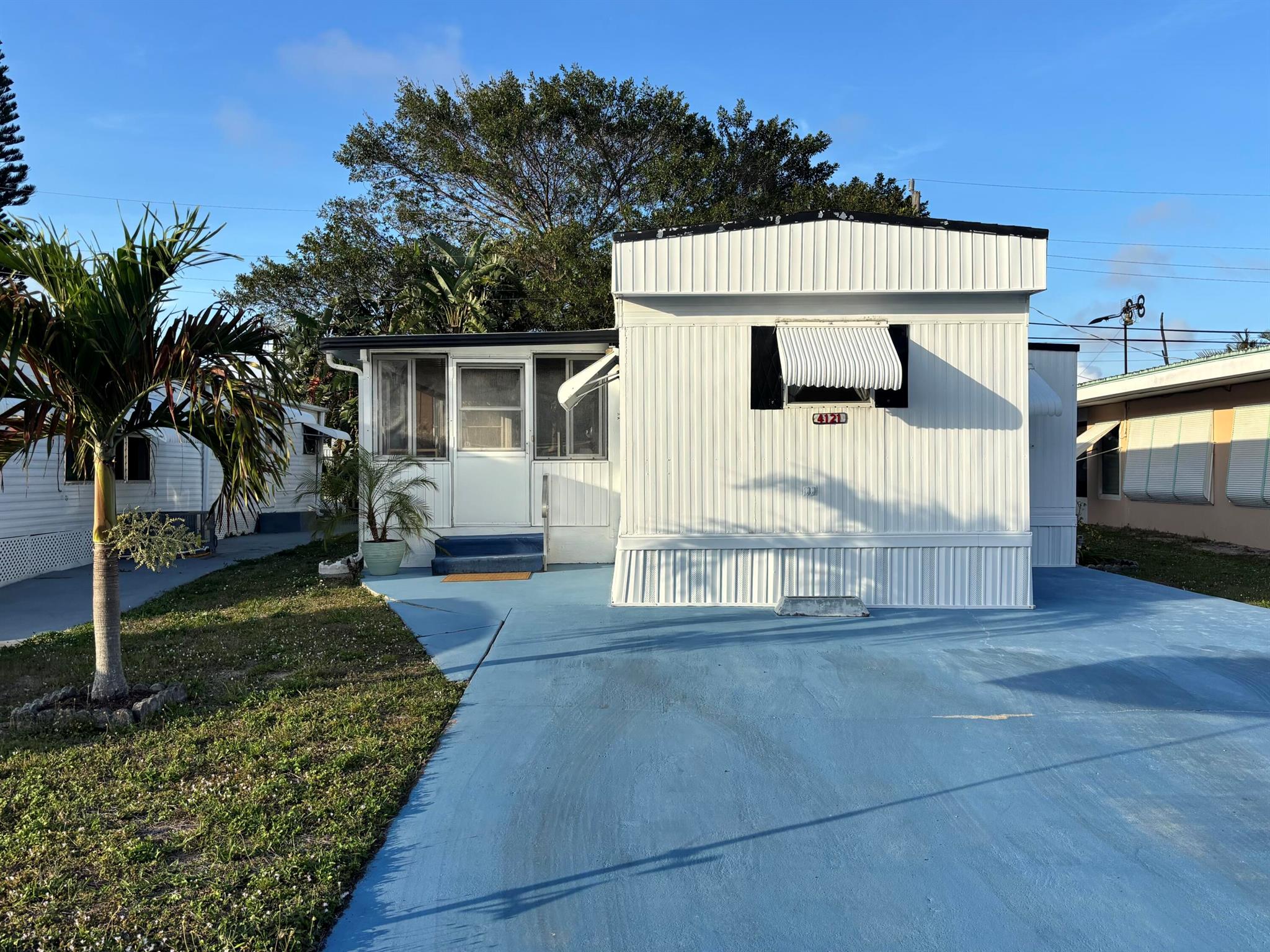 LOW HOA + NO LAND LEASE + LOW RE TAXES = AFFORDABLE LIVING! Enjoy Florida life at its best in this charming single-wide offering a simple yet inviting facade complemented by furnishings that enhance its relaxed atmosphere. A seasonal or year-round residence, the home provides comfortable living with thoughtful design. A spacious living area flows seamlessly into the FL room, perfect for unwinding or entertaining. The kitchen island provides ample storage plus seating for casual dining. The split-BR floor plan ensures privacy for both owners & guests, w/each BA featuring a step-in shower. A side door & entry door allow for a refreshing cross breeze. The neat patio is perfect for grilling & is adjacent to a storage shed housing a full-size washer/dryer adds to the home's functionality.
