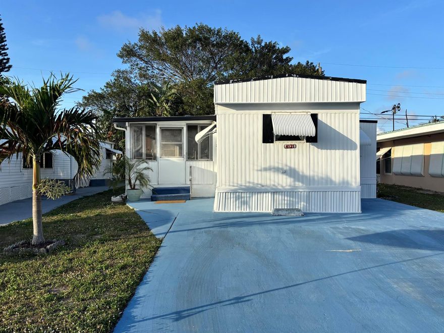 LOW HOA + NO LAND LEASE + LOW RE TAXES = AFFORDABLE LIVING! Enjoy Florida life at its best in this charming single-wide offering a simple yet inviting facade complemented by furnishings that enhance its relaxed atmosphere. A seasonal or year-round residence, the home provides comfortable living with thoughtful design. A spacious living area flows seamlessly into the FL room, perfect for unwinding or entertaining. The kitchen island provides ample storage plus seating for casual dining. The split-BR floor plan ensures privacy for both owners & guests, w/each BA featuring a step-in shower. A side door & entry door allow for a refreshing cross breeze. The neat patio is perfect for grilling & is adjacent to a storage shed housing a full-size washer/dryer adds to the home's functionality.