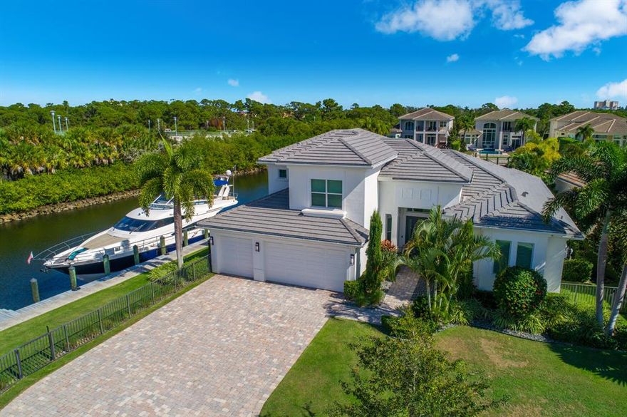 Impeccable custom model home surrounded by 240' of water frontage that can accommodate up to 100 ft yacht. This stunning corner lot residence features 4061 AC SF with 4 bedrooms + loft, 5.2 baths, 3 car garage & dual docks in the exclusive gated community of Frenchman's Harbor.  Located on a cul-de-sac with direct Intracoastal access and no fixed bridges, the property includes 2 private docks - one 100 ft & the other 70 ft with 13K lb lift. A spacious split floor plan offers 2 ground floor master suites & panoramic water views from every room. The gourmet chef's kitchen features a cook island with 6-burner gas Wolf stove, SubZero refrigerator, double wall ovens, custom backsplash, quartz counters & custom 42'' cabinetry with crown molding. The first master suite features coffered ceiling