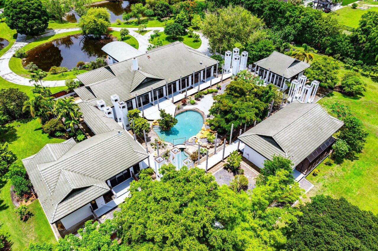 Contemporary Equestrian Estate on 5 Lush Acres with Guest Houses & Courtyard PoolA rare and private offering, this architecturally striking contemporary estate is sited on 5 verdant acres and offers approximately 8,000 square feet of living space. Designed around a serene courtyard garden and rock-rimmed pool, the main residence is a masterpiece of volume and light, featuring cathedral ceilings, wide plank walkways, and a dramatic stone fireplace anchoring the living room. Expansive windows with transoms frame views of private gardens, a tranquil Japanese garden, and a koi pond--infusing the home with a Zen-like sense of harmony and calm. Inside, the residence offers gracious entertaining spaces, a stunning custom bar, a private movie theater, and three bedrooms, with plans available