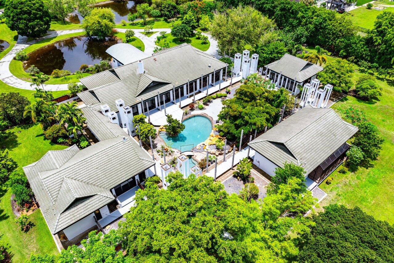 Contemporary Equestrian Estate on 5 Lush Acres with Guest Houses & Courtyard PoolA rare and private offering, this architecturally striking contemporary estate is sited on 5 verdant acres and offers approximately 8,000 square feet of living space. Designed around a serene courtyard garden and rock-rimmed pool, the main residence is a masterpiece of volume and light, featuring cathedral ceilings, wide plank walkways, and a dramatic stone fireplace anchoring the living room. Expansive windows with transoms frame views of private gardens, a tranquil Japanese garden, and a koi pond--infusing the home with a Zen-like sense of harmony and calm. Inside, the residence offers gracious entertaining spaces, a stunning custom bar, a private movie theater, and three bedrooms, with plans available