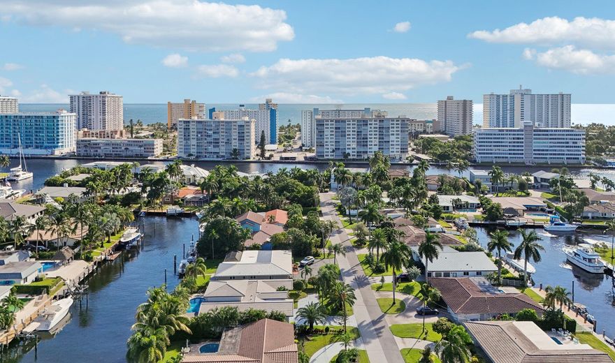 100FT-wide protected T-shaped canal—located on 80FT no fixed bridge deepwater frontage. An elite yachtsman's and fisherman's canvas to tailor for ip to a 65-70FT vessel. Direct ocean access with just a 10-15 minute run to The Hillsboro Inlet. This refined coastal-modern residence features an open split floor plan featuring three suites with cabana bath, New PVC plumbing, travertine floors, and full impact glass windows and doors. Designer chef's kitchen with custom cabinetry, gas cooktop, premium appliances, and wine chiller. Interior laundry with natural gas, & separate washer/dryer room. Updated Resort-style heated pool and lush greenery. Spacious primary suite with custom closet overlooks the waterway/pool from 2 sets of glass doors Only 5 blocks to the beach, dining, and entertainment!
