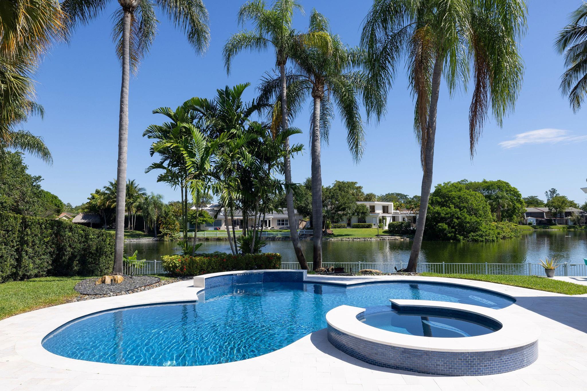 Located in the coveted Lakes of Emerald Hills, this fully renovated 6-bedroom, 5-bath home plus office offers timeless style and everyday comfort. Set on a peaceful lakefront lot, it’s move-in ready with thoughtful upgrades throughout. The kitchen features KitchenAid appliances, dual ovens, and a clean, functional layout that opens to the living and dining areas. Bathrooms feature decorative tile and updated finishes. The primary suite includes double walk-in closets and a renovated bath with dual vanities, a soaking tub, and a walk-in shower. Outside, enjoy a pool, built-in hot tub, covered patio, and outdoor dining area. This home offers space, style, and a lifestyle like no other.