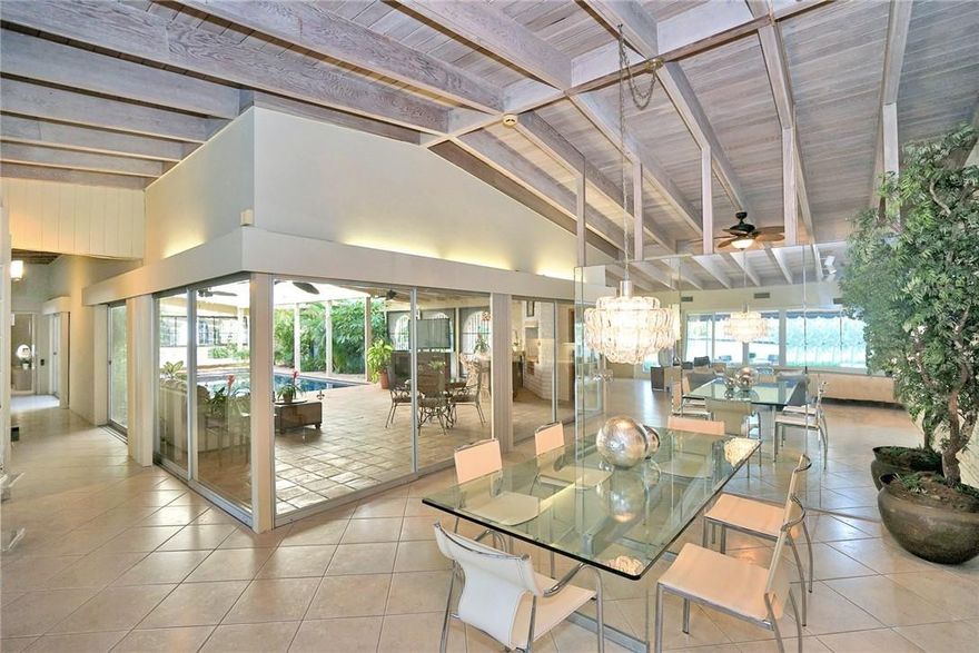 MID CENTURY JEWEL ON WATER W/ AN  "OLD HOLLYWOOD" FEEL.   CUSTOM BLT  IN 1955 BY ROBERT RICKLE AS HIS PERSONAL HOME & W/ THE  INTERIOR  INTEGRITY REMAINING TO THIS DAY;  AS PRESENT OWNER HAS LIVED IN HOME FOR OVER 50 YEARS!   ORIGINAL  WHITE WASHED CATHEDRAL  BEAMED CEILINGS ARE IN ALL ROOMS & CONTINUE IN HALLWAYS, COCINA CUT STONE WALL SOARS TO CEILING IN LIVING ROOM & DINING ROOM.  WALLS OF GLASS SLIDING DOORS OPEN THE ENTIRE HOME & POCKET OVER EACH OTHER TO 64X29 FAMILY ROOM W/ HIGH BEAMED CEILING, LUSH TROPICAL LANDSCAPING & AMAZING  OVERSIZED TILED POOL.  KITCHEN CABINETS APPEAR TO FLOAT & BEAMED CEILING CONTINUES THRU KITCHEN & LAUNDRY ROOM.  LG MARBLE MASTER BATH, 90X12 CANVAS COVERED PATIO FACES 100 FT. ON  MIDDLE  RIVER. ALL IMPACT GLASS OUTSIDE; BUT NOT INTERIOR GLASS DOORS.