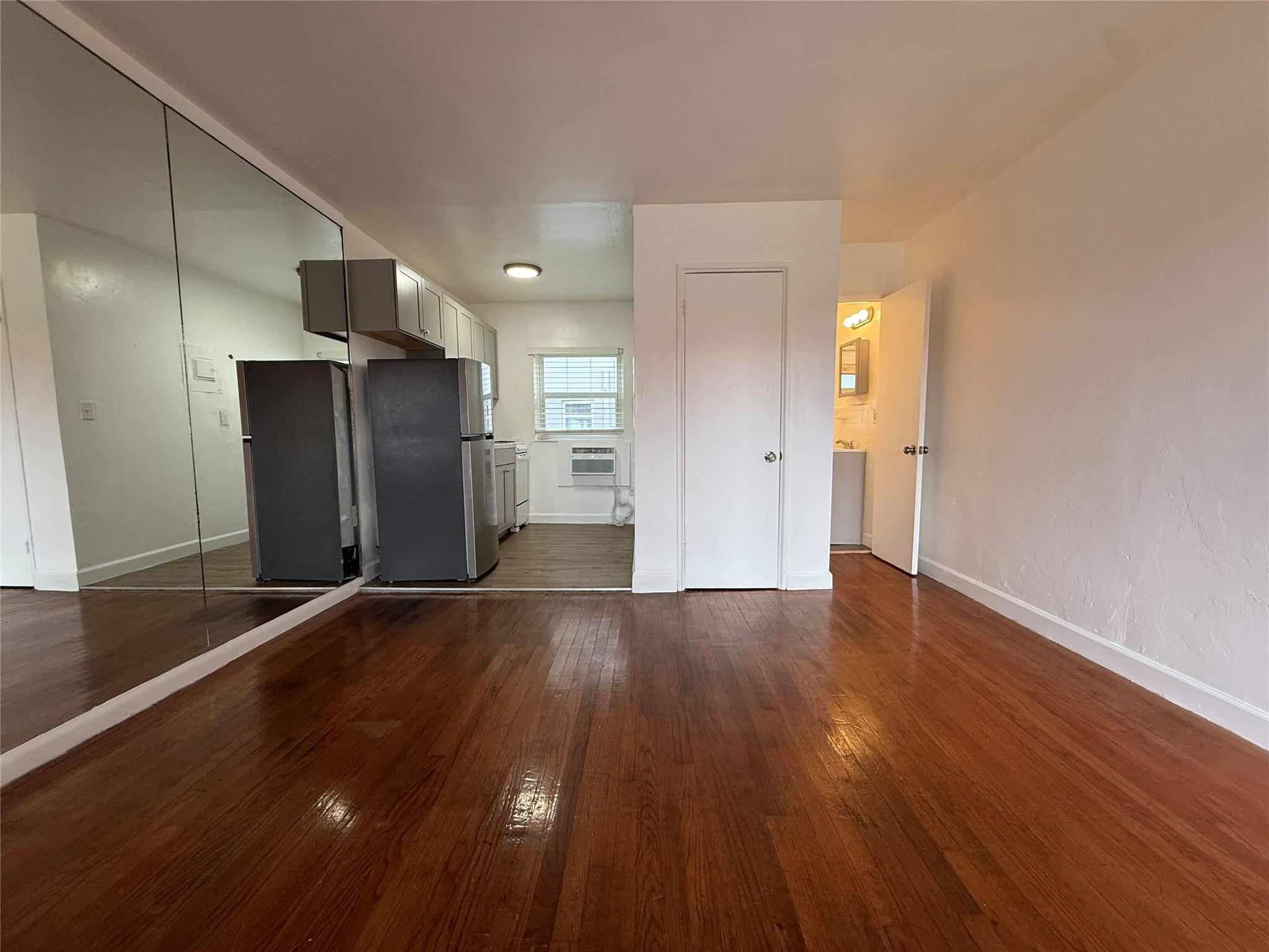 Cozy and bright studio apartment located in the heart of Hollywood, FL! Featuring gleaming hardwood floors and a functional layout, this unit offers a separate kitchen with modern cabinetry, full-size refrigerator, and ample storage space. The living area boasts natural light through large windows with charming views. The retro-inspired bathroom is well-maintained with colorful tile accents. Additional highlights include built-in air conditioning and a mirrored wall for an open feel. Conveniently located near shopping, dining, and entertainment, this apartment is perfect for urban living. Pets welcome, no aggressive breeds.