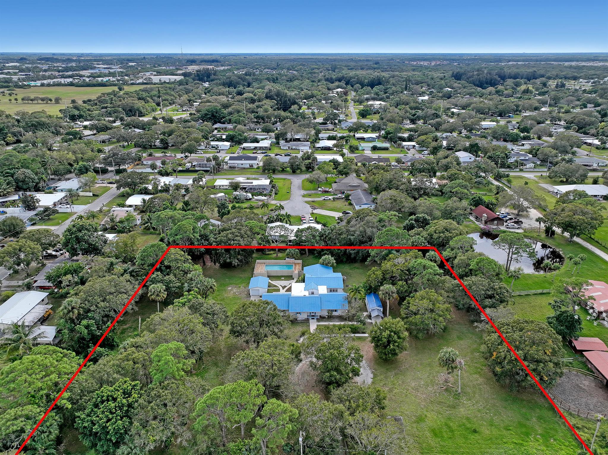 Do No Bother Tenant! NEW PRICE REDUCTION - on 2.3 serene acres in a quiet residential neighborhood with easy access to I-95 and the Turnpike, this charming residence blends mid-century character with incredible potential. The original 1950 concrete block home--complemented by a thoughtfully added front addition with stucco-over-wood exterior--offers solid bones and a flexible layout ready for your personal touch. Inside, the home features spacious living areas with room to reimagine and update, especially the bathrooms and flooring, to suit modern lifestyles. The home's layout invites creative renovation opportunities while preserving its enduring charm.Outdoors, enjoy the Florida lifestyle with a private pool and fully fenced-in courtyards--perfect for pets, entertaining or relaxation