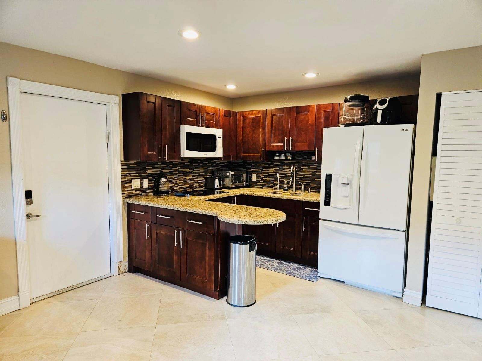 ALL UTILITIES INCLUDED! Beautifully updated 1BR/1BA apartment in a quiet neighborhood in Davie with private side entrance, located in a separate building behind the main home. This 600 sq ft unit features an open floor plan, modern kitchen with granite counters, stainless steel appliances, built-in closet system, tile flooring throughout, and updated bathroom. Enjoy a private side yard and on-site laundry room. Can be rented furnished or unfurnished. Quiet, private, and available for occupancy August 1. Prime location near highways, shopping, and dining.