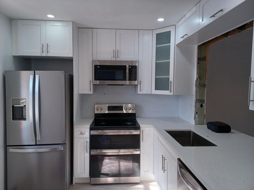 Beautifully remodeled 2-bedroom, 2-bath condo offering a fresh, modern feel throughout. This inviting interior unit features a stylish open kitchen with quartz countertops, stainless steel appliances, updated cabinetry, and a seamless flow into the living space. The primary bathroom has been tastefully renovated, and new vinyl flooring runs throughout. Enjoy smooth ceilings with no popcorn and a freshly painted interior that feels clean and move-in ready. Palm Village is investor friendly for all ages and offers a community pool and fitness center, with association dues covering insurance, water, sewer, trash, lawn care and ammenities. Conveniently located near shopping, dining, parks, Publix, Trader Joes, Coral Square Mall, and The Walk. Ideal location for all ages.