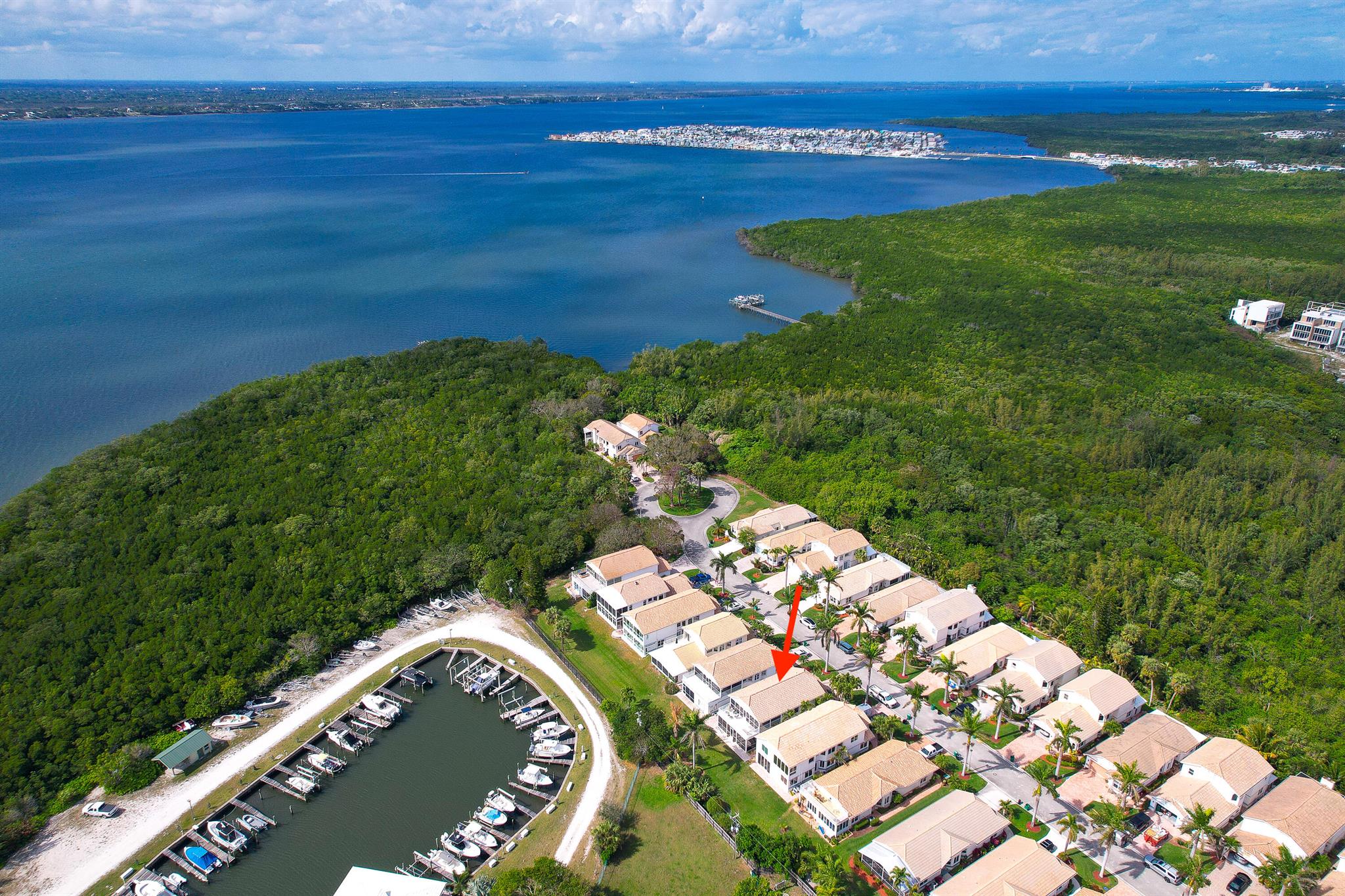 Experience coastal luxury at its finest in this completely reimagined 3-bedroom, 2.5-bath residence within the prestigious gated community of Bay Tree on South Hutchinson Island. One of only 32 homes, this impeccable two-story property boasts a spacious open floor plan, soaring vaulted ceilings, and a first-floor primary suite. Enjoy the peace of mind provided by impact glass windows, stylish new luxury vinyl flooring, and the convenience of an attached garage. A Sonos music system enhances the ambiance throughout. Upstairs, a screened lanai with open balcony and lower screened patio offer southern exposure and picturesque marina views. The chef's kitchen is a masterpiece, showcasing custom cabinetry and premium KitchenAid stainless steel appliances.