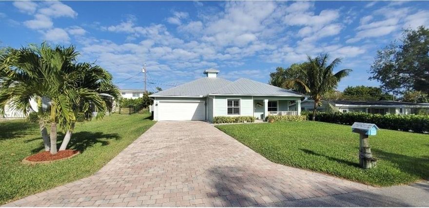Beach vibes abound in this turn-key, oasis in the heart of Jensen Beach's Skyline Heights Community. This CBS built gem boasts 3 large bedrooms, 2 updated bathrooms and a spacious open concept floor plan with numerous upgrades.  Updated kitchen includes granite counters, stylish backsplash, stainless steel appliances, spacious island, and pantry storage. The living room opens up to a newly installed screened porch and paved backyard space perfect for entertaining and relaxing by the firepit. Home also features a lush lawn with sprinkler system, plantation shutters, and easy to install hurricane panels. Paved driveway provides ample room for all your parking needs. Don't miss this opportunity to own a slice of heaven where evening golf cart rides to dinner in downtown Jensen are a breeze.