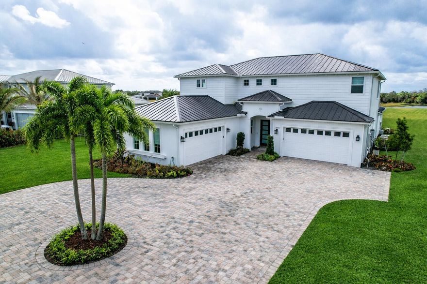 Experience a RARE level of LUXURY in this completely reimagined estate, ideally positioned on one of the LARGEST and most PRIVATE lots within the prestigious Bridgewater community of Jupiter. Set on an expansive 2-acre cul-de-sac parcel with tranquil water and sunset views, this NEVER LIVED IN, NEW CONSTRUCTION residence offers over 7,000 total square feet of thoughtfully designed living space. This exceptional home features 6 bedrooms, 5.1 bathrooms, a private office, loft, theater room, and a spacious 4-car garage—all curated with designer finishes and extensive, high-end upgrades throughout. Step through impact glass double entry doors into a grand foyer with soaring volume ceilings and a light-filled open floor plan. The main living areas are designed to maximize natural light while framing breathtaking views of the outdoor living space. Zero-corner sliding glass doors seamlessly disappear, creating a true indoor-outdoor lifestyle experience. At the heart of the home is a stunning, custom-designed chef's kitchen, showcasing rich oak cabinetry, sleek quartz countertops, under-cabinet lighting, and a full suite of top-tier JennAir appliances. The centerpiece is the impressive 48-inch professional JennAir range, elevating everyday cooking into a culinary event. Additional highlights include a double-door refrigerator, dual dishwashers, custom hood, wine refrigeration, and an expansive walk-in pantry with custom built-ins. The main-level primary suite is a private retreat, complete with a sitting area and French doors opening to the lanai. The custom walk-in closet features full oak built-ins with integrated lighting, while the spa-inspired bathroom offers dual vanities and a spacious walk-in shower with modern designer finishes. Also on the main level: a formal dining room with wet bar, an eat-in kitchen area, private office, and a guest suite. A striking designer powder room adds sophistication, while the laundry room is outfitted with Bespoke Samsung washer and dryer, quartz countertops, and custom cabinetry. A dramatic hardwood spiral staircase leads to the upper level, where a loft overlooks the main living space below. Upstairs features four additional bedrooms, each with custom closets, along with a large theater room—perfect for a media room, playroom, or additional guest space. Wide-plank oak hardwood flooring flows throughout the entire upper level. The outdoor space is the ultimate blank canvas. The expansive covered lanai is ideal for entertaining and relaxation, overlooking peaceful water views. With 2 FULL ACRES, the property offers endless possibilities for a custom pool, outdoor kitchen, sports courts, gardens, or a private resort-style retreat. A rare opportunity to own a brand-new, never-lived-in luxury estate on one of Bridgewater's most desirable lots.