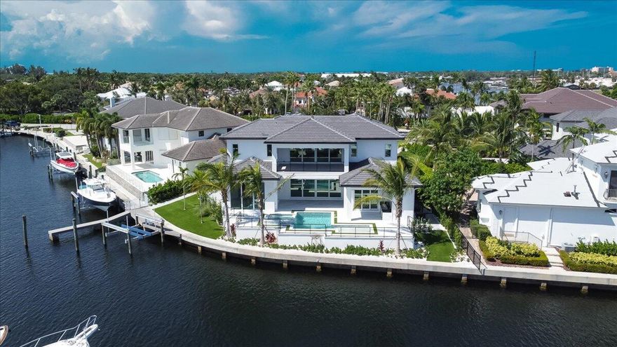 Prepare to be impressed by this newly completed custom home.  Amazing views of the marina and intracoastal with 137' of waterfrontage.  Lighted, coffered ceilings in every room.  Ten foot tall sliders let light in and provide panoramic views.  Boat dock with 20,000 lb lift.  Natural gas supplies the water heaters, fireplace, summer kitchen, pool heater and stove.  Spacious island kitchen with quartz countertops and a Thermador appliance package.  12 x 60'' wood look porcelain tile thru-out.  Custom saltwater / heated pool with sun shelf and spa.  Retractable screens on the patios.  Summer kitchen, marble pool deck, artificial turf and cabana bath.  Sonos system with speakers. Spacious patio and balcony.   Exterior cameras with recording system.  Built-in closet cabinets.  Gated community.