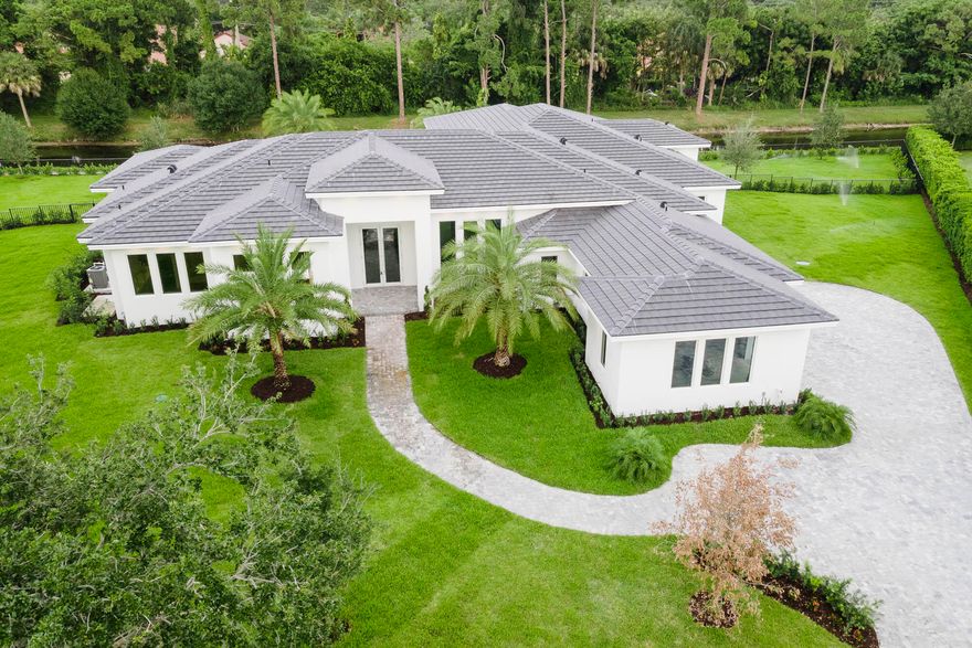 Set on a sprawling home site in Steeplechase, one the most prestigious gated neighborhoods in Palm Beach Gardens, you will find serenity redefined. This brand new custom estate home is fully built and move-in ready. A modern masterpiece on a private 1 acre lot with 5 bedrooms, 7 baths + office/club room, 3.5 car garage, and over 5,000 sq ft. This elegant design features huge 14ft volume ceilings, modern open layout that provides seamless transitions from the main living area to the other sections of the home. The incredible level of detail and ultra high end finishes puts this property in a league of its own. In the spacious gourmet kitchen you'll find Italian porcelain flooring, double waterfall quartz countertops, custom European cabinetry, and top of the line Sub-Zero & Wolf Appliances.