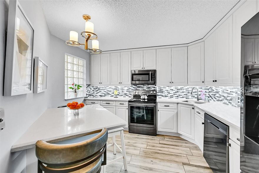 Welcome to this stunning third-floor condo! This 3/2 oasis offers an expansive open floor plan with vaulted ceilings and beautiful porcelain tile floors mimicking wood in the main living areas. The main bedroom offers a walk-in closet and private access to the enclosed patio. 3rd room is currently used as a DEN. The elegant kitchen boasts quartz countertops, stainless steel appliances, and white cabinetry with built-ins. Enjoy the convenience of a laundry room with full-size washer and dryer with extra storage. 2024 AC & 2019 Water heater Community amenities include a gym, heated pool, spa, tennis and basketball courts, & a theater. The Bayview fee covers water, cable, internet, & more, ensuring a worry-free lifestyle. The roof was replaced in 2023, & the building exterior painted in 2024.