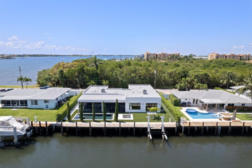 This gorgeous, contemporary, move-in ready, newer construction home is a boater's dream, with over 90 feet of waterfrontage, a rebuilt seawall, and a new 20,000 lb boat lift--just 1.3 miles from the Boynton Inlet and the Atlantic Ocean. High-end features include large-format porcelain flooring throughout, top-of-the-line impact windows and doors, a full-home generator, a reverse osmosis water filtration system, a state-of-the-art security system, and more. The gourmet chef's kitchen is equipped with custom wood cabinetry, marble countertops, and top-of-the-line Monogram appliances. The spacious primary suite offers two oversized walk-in closets and a luxurious five-piece bathroom.