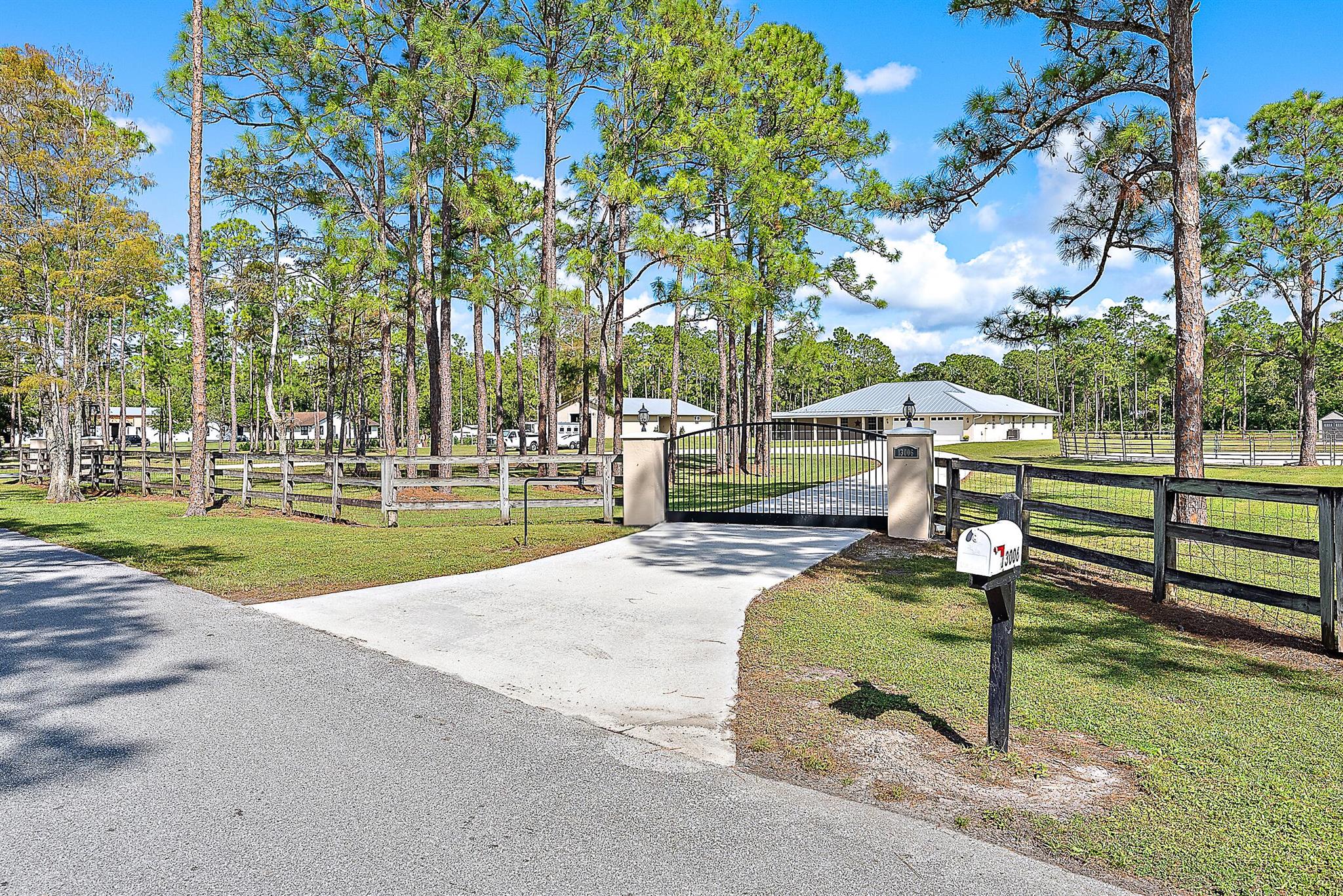 An incredible value in the sought-after Palm Beach Gardens equestrian community of Caloosa, this solid CBS (concrete block) home, featuring a 2022 metal roof and a 2018-built 2,000+ sq ft barn, offers one of the best values in the area. Set on 5 fully fenced acres with private gates, this property provides an ideal combination of quality, functionality, and peace of mind. The one-story home features a split floor plan, generous 702 sqft garage, and both front and back screened porches, providing a comfortable and move-in ready living space. The 2018-built center-aisle barn is a true standout, with 5 stalls, climate-controlled feed and tack rooms, and multiple turnouts and paddocks. Caloosa residents enjoy low HOA dues along with miles of trails, a 32-acre horse park, pickleball courts, a