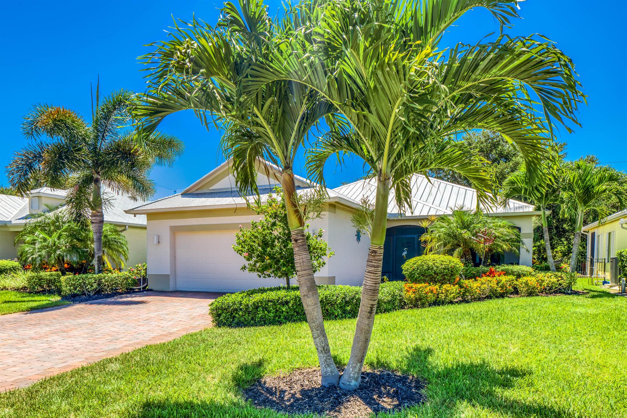 Embrace relaxed coastal living in this beautifully maintained GHO Bimini model, lightly used as a 3 bedroom, the versatile den has a closet added. Nestled against a peaceful wooded preserve, this home offers rare privacy and a tranquil backdrop. Designed with a coastal flair, it features light, airy interiors, crown molding, arched doorways, and decorative niches throughout. Enjoy durable, high-end finishes including impact glass, a metal roof, and natural gas service for efficiency and peace of mind. Outdoor living shines here with a screened front porch and screened lanai in the back, an enlarged paver driveway that adds both charm and functionality. Ideally located just a short stroll from the clubhouse with pool and fitness center, and directly across from the Osprey Nature Preserve