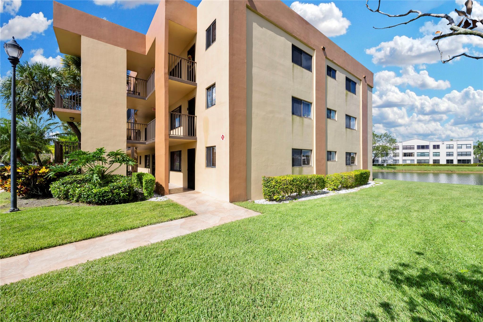 55+ active resort-style community. Breathtaking expansive lake view from all bedrooms. First floor Ashmont condominium, corner unit with expansive windows. New washer & dryer & water heater. Enclosed porch with window & a door. Gated community. Active lifestyle that includes various clubhouse activities, indoor & outdoor pools, tennis, pickleball, & great social events. Water, basic cable, internet & association amenities included in the Condo fees. No leasing permitted. Laminate wood floors in the primary bedroom. 2 large walk-in closets.