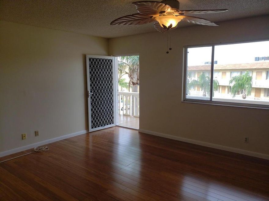 Don't miss this rare opportunity to own a spacious top-floor one-bedroom, one-and-a-half-bath condo in a beautifully maintained 55+ community! Step into an oversized bedroom with an abundance of closet space, perfect for all your storage needs. Enjoy your morning coffee or evening breeze from the private screened balcony. Feel safe and secure with a set of roll down hurricane shutters to protect you from a storm. The modern kitchen features updated cabinetry and sleek granite countertops, while the rich wood flooring adds warmth and elegance throughout. With a newer A/C (just 4 years old), you'll stay comfortable year-round. Nestled in a serene, park-like +55 setting with low monthly fees (which even include basic cable), this home offers incredible value in a prime location.