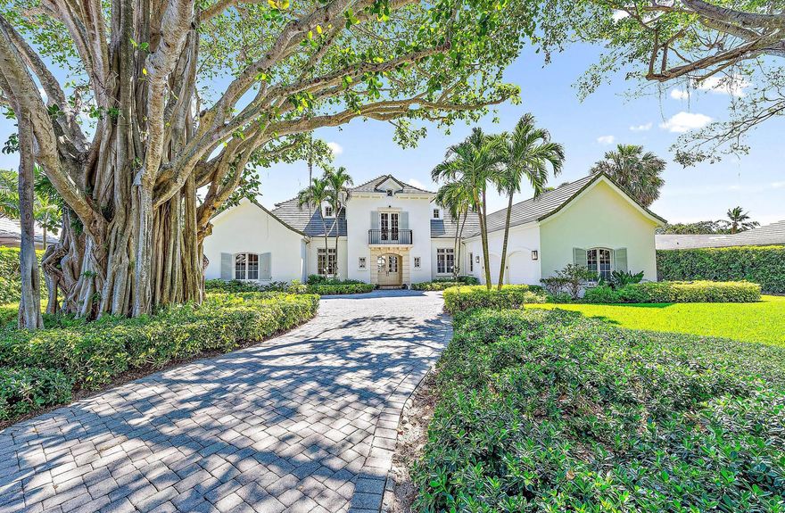 This exquisite golf course estate boasts breathtaking double fairway water views and unparalleled privacy. The property features a magnificent legacy tree and a grand entrance that sets the tone for the entire experience. Inside, you'll find soaring ceilings with elegant coffered designs, arched door frames, a modern fireplace, and french doors that enhance the sophisticated coastal style. An open and inviting floor plan includes 4 bedrooms and 4 full bathrooms plus 1 half bath. Abundant natural light floods in through numerous windows, illuminating the spacious kitchen and living areas. The expansive first-floor master suite provides direct access to the outdoor oasis and additional guest accommodations upstairs are each complete with a balcony for added luxury.