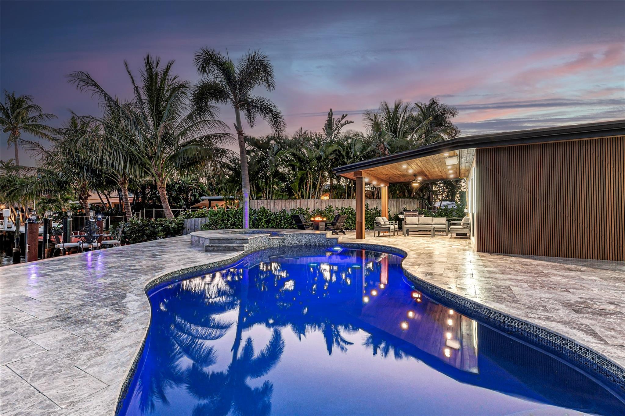 Welcome home to the gem of Garden Isles! No expense was spared in this stunning, fully renovated modern retreat in the heart of Pompano Beach. This waterfront paradise boasts 60 ft of seawall and prime unobstructed canal views, travertine patio, al fresco dining and outdoor kitchen, refinished heated pool and spa, luxury finishes, large profile tile floors, rich teak accents, exposed beams, modern fireplaces, custom cabinetry throughout, full impact windows and doors, electric privacy shades in every room, and a fully equipped garage gym. The primary wing boasts a resort-inspired ensuite with curbless shower and soaking tub, double vanity and a gorgeous walk-in closet with under cabinet lighting, complete with sliding doors leading out to your private backyard oasis. Truly one of a kind.