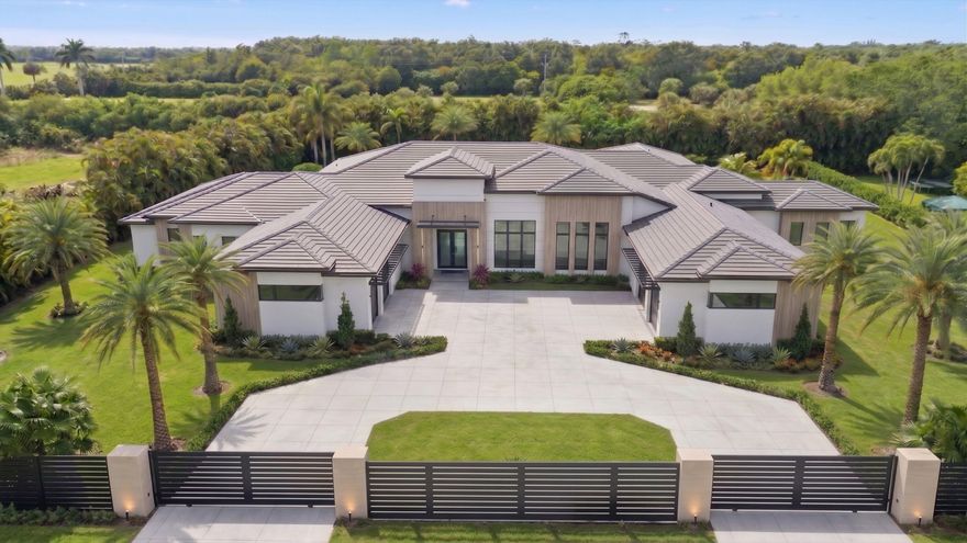 Elite opportunity to purchase this new estate in the prestigous Southfields community in Wellington. Unite with the builder now, currently in mid phase construction to enable your personal flair on this unique homes finishes. This contemporary masterpiece boasts a total of 8,005 sqft of indoor living, in addition to the 2,206 covered patio that overlooks a detailed outdoor oasis. Inside the home, a grand entrance featuring a 6 x 10 pivot front door welcomes you and directs attention the 12- 16.5 ceilings throughout the entire house. 48 x 48" Tile floors grace the estate and you will admire the extra wide hallways and doors as you tour the open concept living area featuring a custom walk-in wine cooler, a gourmet chefs kitchen with top class Miele/ Sub Zero appliances, butlers pantry,  a double island with bold 2.5" thick countertops, and ground to ceiling cabinetry. The split concept primary suite is its own spa-inspired wing that features two roomy walk in closets, morning bar, a 464 sqft primary bath with glass enclosed steam shower, soaking tub, two water closets with Toto seating, and two separate vanities. Included in the private suite wing is a recovery room with cold plunge tub and large sauna. On the north wings you will encounter four additional en suite bedrooms, mudroom with dog wash station, fitness room, and sports room with custom bar for entertaining guests. In addition, a formal dining room, dedicated office, and two half baths are also showcased.    The outdoor oasis is a luxurious resort style space that is sure to impress the most particular homeowner. In its center is a 20 x 36 ft. heated, saltwater pool that is flanked by firebowl features and jetted spa, outdoor kitchen, accent lighting, and lush tropical landscaping to complete the private, fully enclosed green space.    This amazing estate also delivers an oversized 4 car garage, ample storage and cabinetry, large dual laundry room, smart home technology, security cameras, upgraded insulation, a 6 zone A/C system with linear grills, and a 1000 gal. propane tank. Entire lot is fully fenced, security system, and a double gated driveway in addition to the newly approved 24 hr. manned guard gate at the forefront of the community.