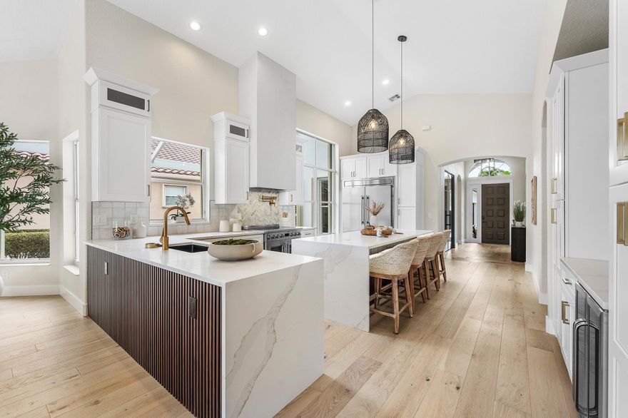 Welcome to this fully reimagined single-story residence offering 3 bedrooms and 2.5 bathrooms, where designer-level renovations and high-end finishes create a truly turnkey living experience. Thoughtfully redesigned throughout, the home features a bright, open layout with high ceilings, clean modern lines, and cohesive, upscale details. At the heart of the home is a stunning, fully renovated kitchen with an oversized island featuring triple waterfall edges, a 60" refrigerator, pot filler, wine refrigerator, built-in microwave, and custom cabinetry. It flows seamlessly into the main living and dining areas, ideal for everyday living and entertaining. A flexible sitting area or office/den complements the spacious main living room filled with natural light. Interior upgrades include white  engineered flooring throughout, solid core doors, upgraded trim, and designer lighting from Restoration Hardware and Arhaus. All three bathrooms are fully renovated, including a luxurious primary suite with dual vanities, soaking tub, and separate shower. Major improvements include an upgraded HVAC system with UV light, new hot water tank, and a whole-house generator. Outdoor living shines with a screened lanai and fully automated saltwater pool and spa with bubblers, lighting, and heating, plus enhanced landscape lighting—perfect for relaxing or entertaining. With designer-quality craftsmanship throughout, this home offers a rare blend of style, comfort, and effortless indoor-outdoor living in a truly move-in-ready setting.