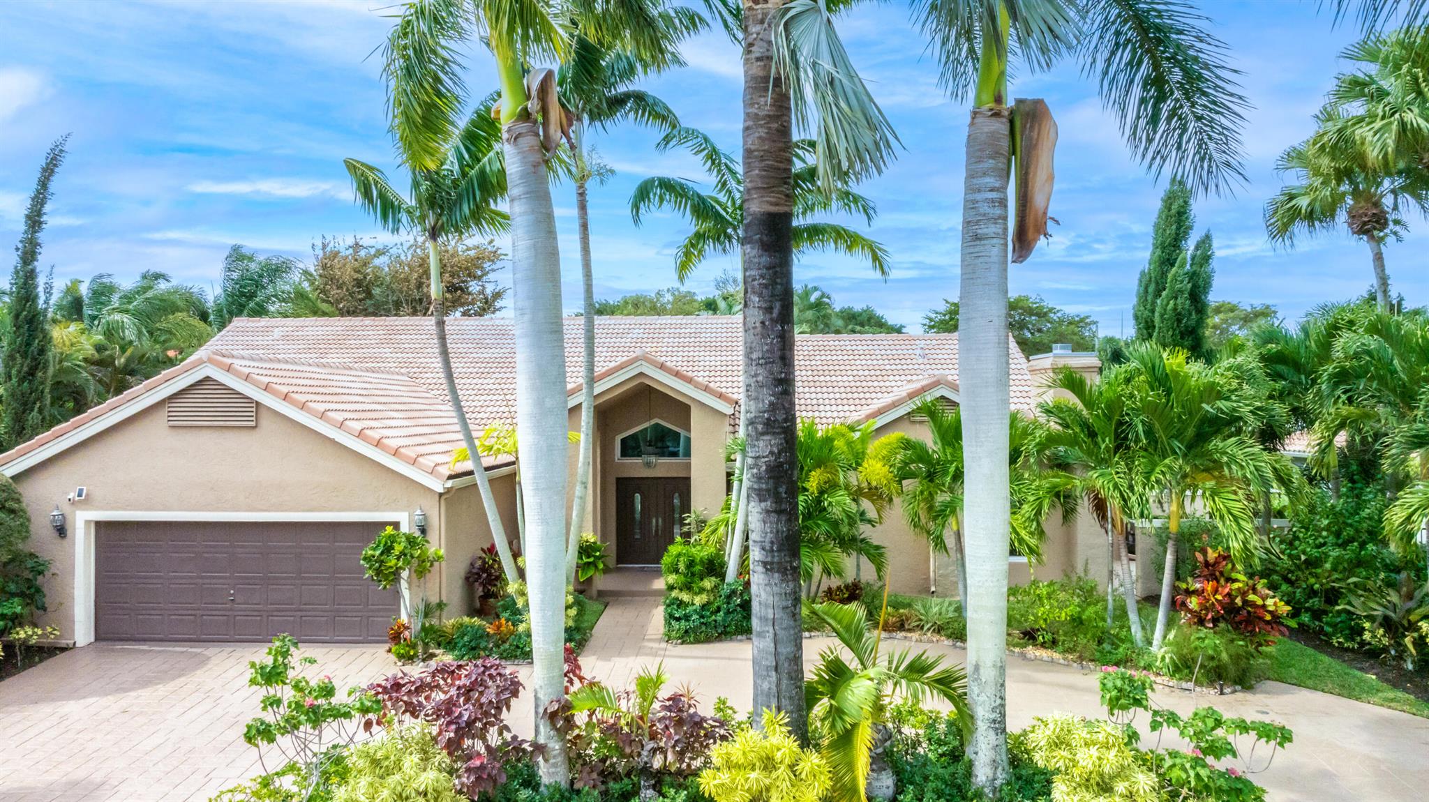 Stunning and serene single level pool home in the exclusive New Floresta in central Boca. This property offers great flexibility with 2973 sq. ft. and an open concept design. Situated on an interior oversized lot, the property affords privacy with lush tropical landscaping and has an extended circular drive. Perfect for entertaining this light & bright property boasts volume ceilings, a split bedroom floor plan, fireplace, wet bar, impact glass throughout, and two new A/C units. Large chef's kitchen has tons of storage and expansive counter space for serving and meal prep. The primary bedroom suite features sitting area, soaking tub, standalone shower, dual sink vanity & custom walk in closet. Relax and recharge by the resurfaced pool and spacious travertine patio. Bonus room. A must see!