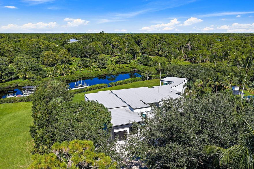 A rare fusion of privacy, precision, and architectural artistry, this minimalist modern masterpiece by Riverside Building & Design rests on over two acres along the North Fork of the Loxahatchee River. Designed to blend with its natural surroundings, it features clean lines, expansive glass, and seamless indoor-outdoor living with tranquil river views throughout. Highlights include a chef's kitchen with luxury appliances and custom cabinetry, a resort-style pool and spa, and a covered summer kitchen for effortless entertaining. A private dock with 16,000-lb lift offers direct access to the Intracoastal and Atlantic Ocean. With sleek design and timeless tranquility, 8309 SE Rivers Edge stands as one of Jupiter's most distinctive and private new waterfront estates.