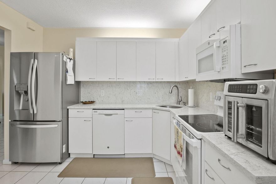 Seller motivated—make an offer! VA Approved! Beautiful top-floor corner unit in Bayside Village. This spacious condo features a split floor plan with approximately 1,100 sq ft. Enjoy a modern kitchen with quartz countertops, white cabinets, and all-new stainless steel appliances. The main areas feature tile flooring, while bedrooms have carpet, & the bathrooms have been updated. Relax on the screened balcony with expansive views of the lake. Both bedrooms offer walk-in closets. Impact windows/doors, washer/dryer, & fresh paint throughout. Residents have access to resort-style Township amenities, including an aquatic center, fitness center, tennis courts, basketball courts, beach volleyball courts, clubhouse, theater, & more. Close to shopping, dining, & highways.