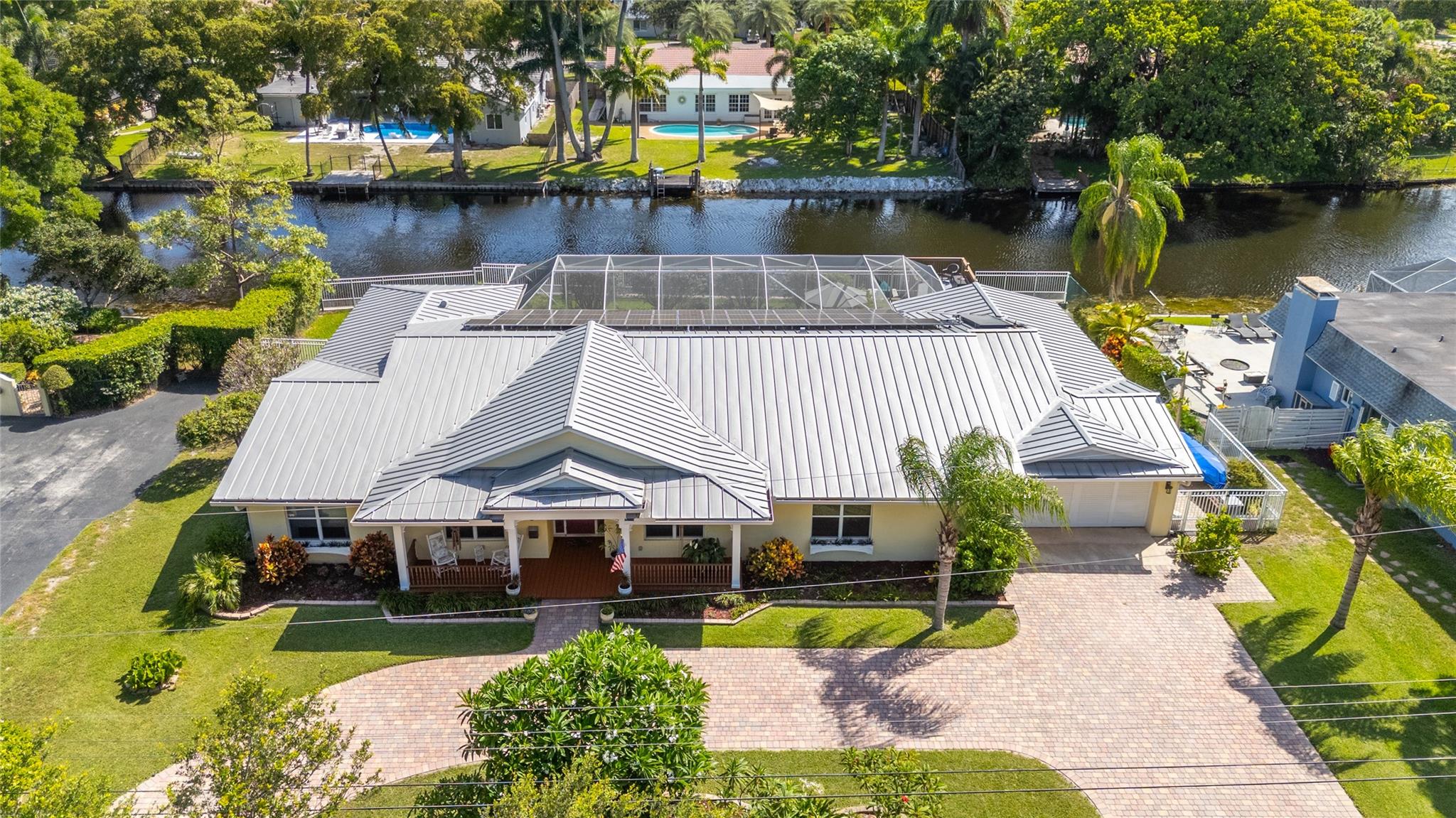Unique Key West–style waterfront retreat in prestigious Golf Estates. Stunning 5 bedroom, 3 bath home w/Den/6th bedroom + tons of storage. Features double split layout w/2 primary suites. Entertain effortlessly w/large living, dining + eat in kitchen, screened heated salt-water pool, hot tub, cabana baths, expansive covered patio, separate firepit area, + a private dock w/floating extension. Side-yard double gates allow boat/RV parking. Upgrades include metal roof, solar ELECTRIC panels, new solar hot-water heater, all-PVC plumbing, elevated seawall, motion-sensory lighting, hard-wired security cameras, 3 A/C units (includes new 5-ton main unit), canal-fed sprinkler system, septic tank, + complete hurricane protection-impact glass + shutters. Close 2 Schools, Malls, Airport, Beach, Casino+